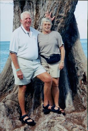 A man and woman standing next to a tree