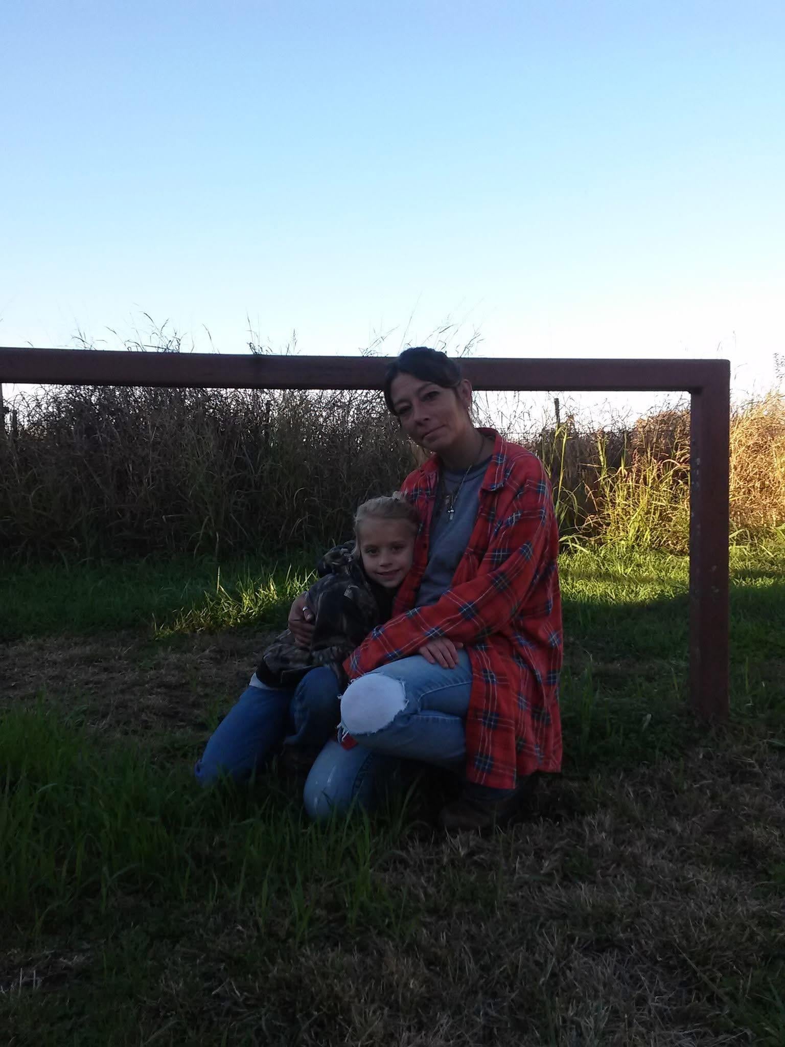 A woman and child sitting on grass