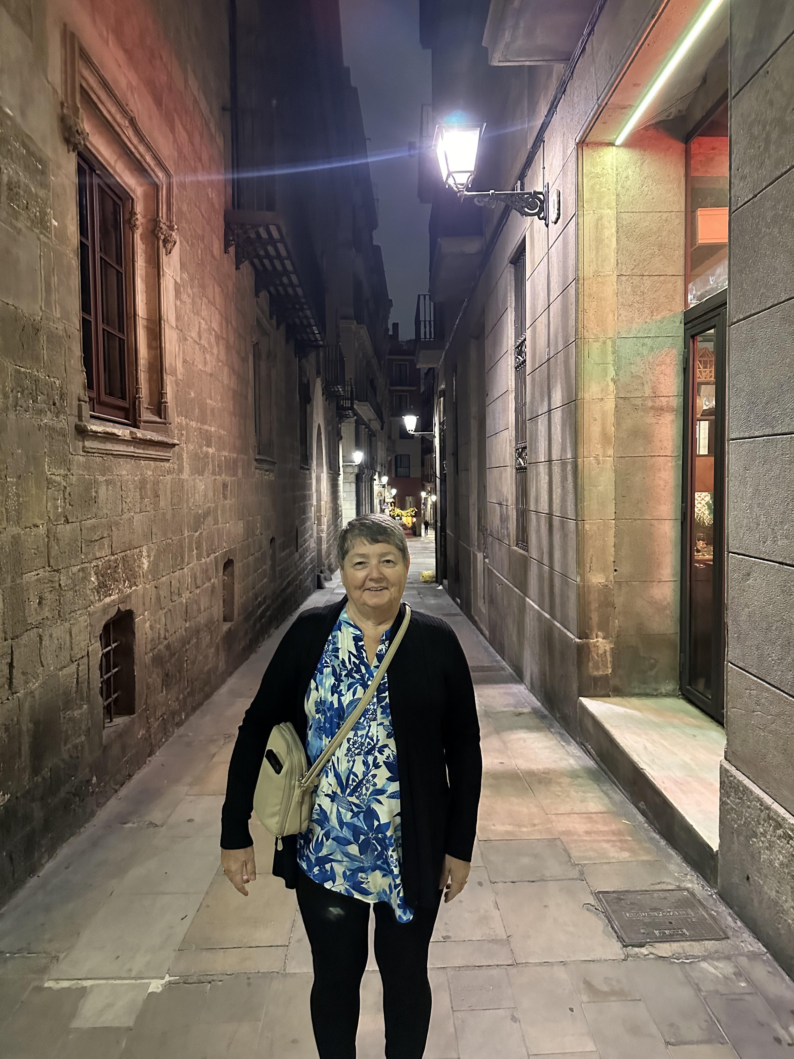 A woman standing in a narrow alley