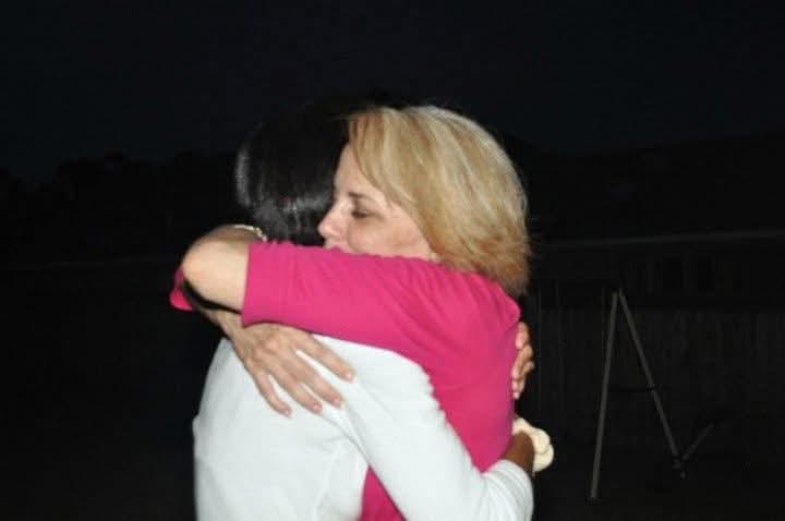 Two women hugging each other