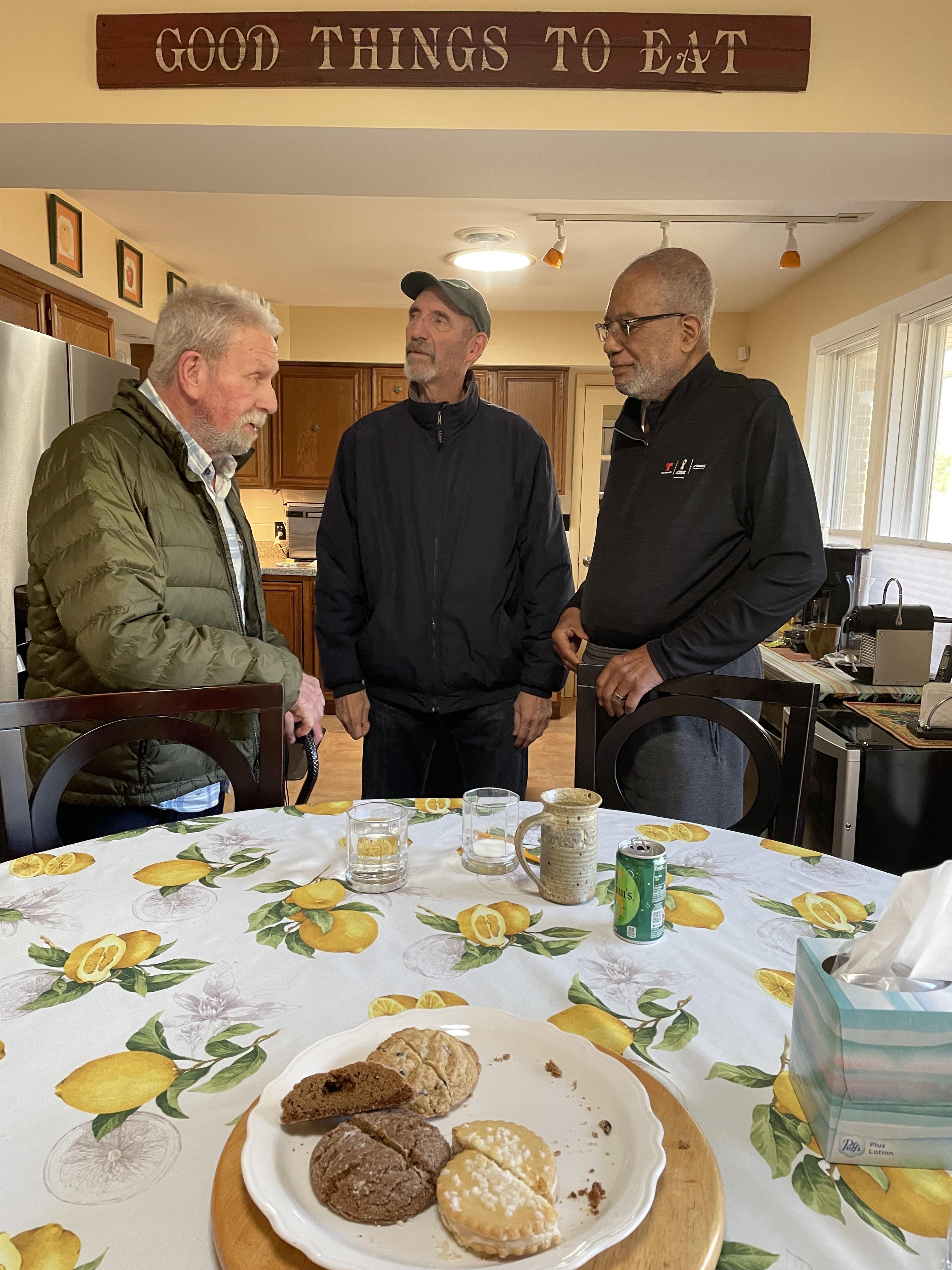 A group of men standing around a table