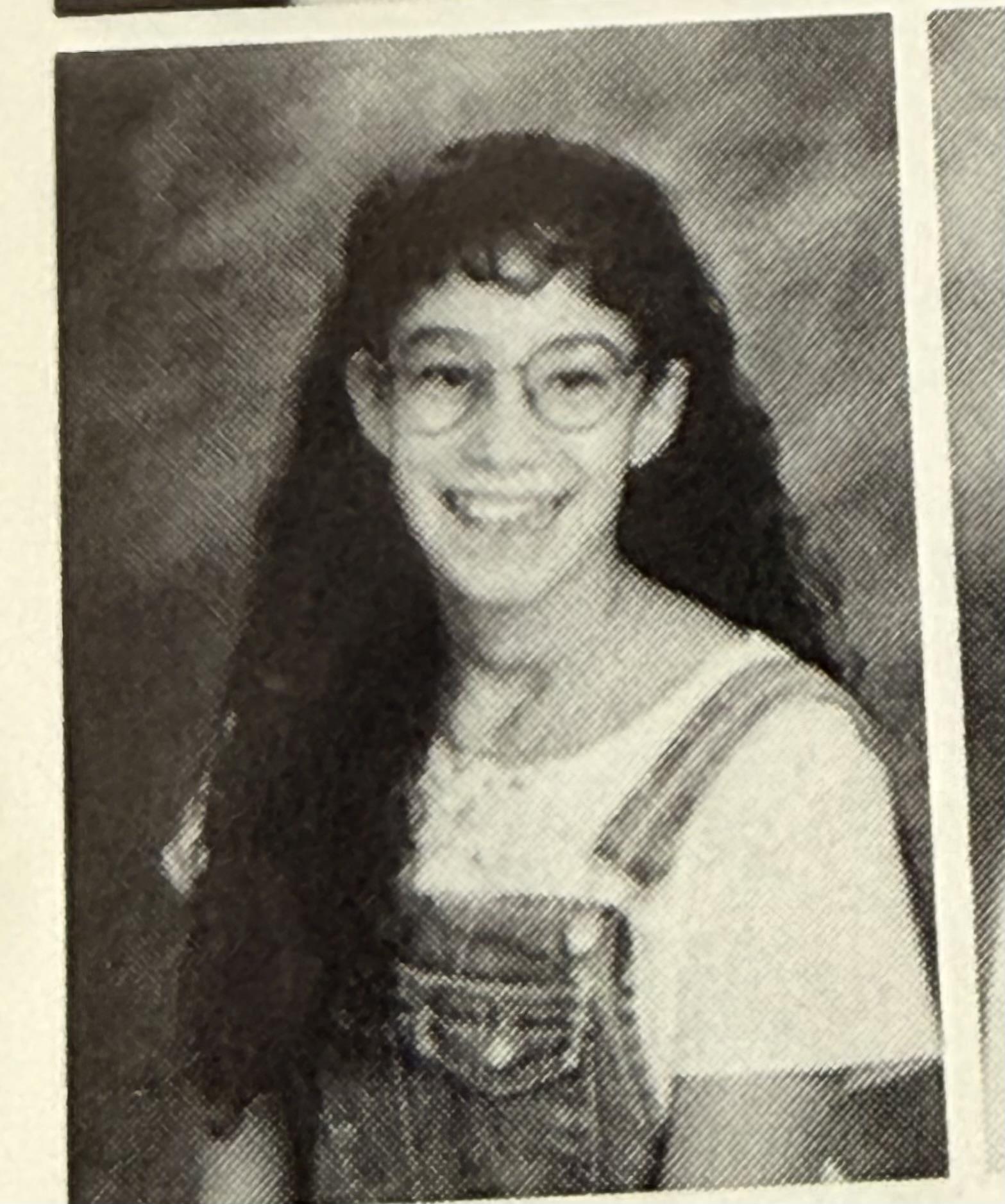 A young woman with long hair wearing glasses