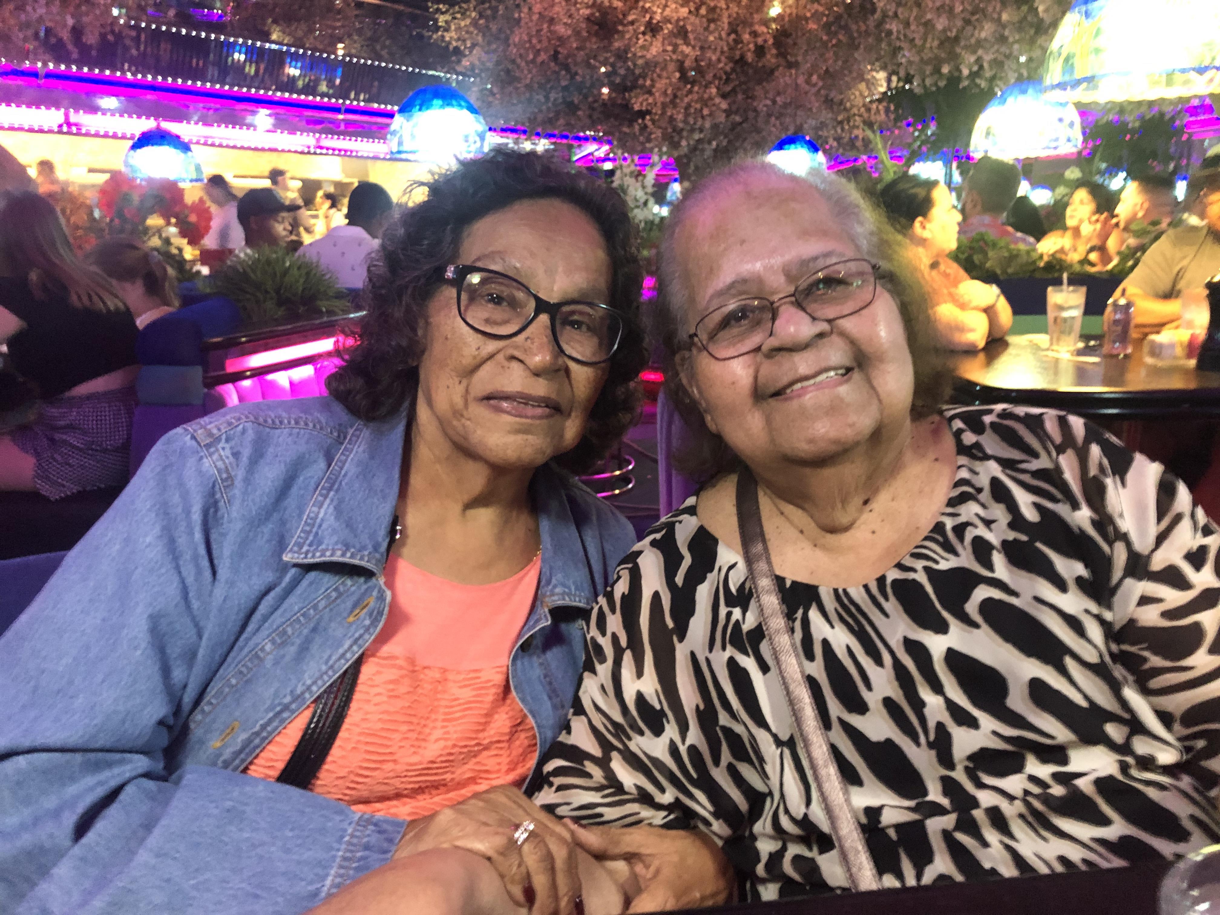 Two women sitting together smiling at the camera