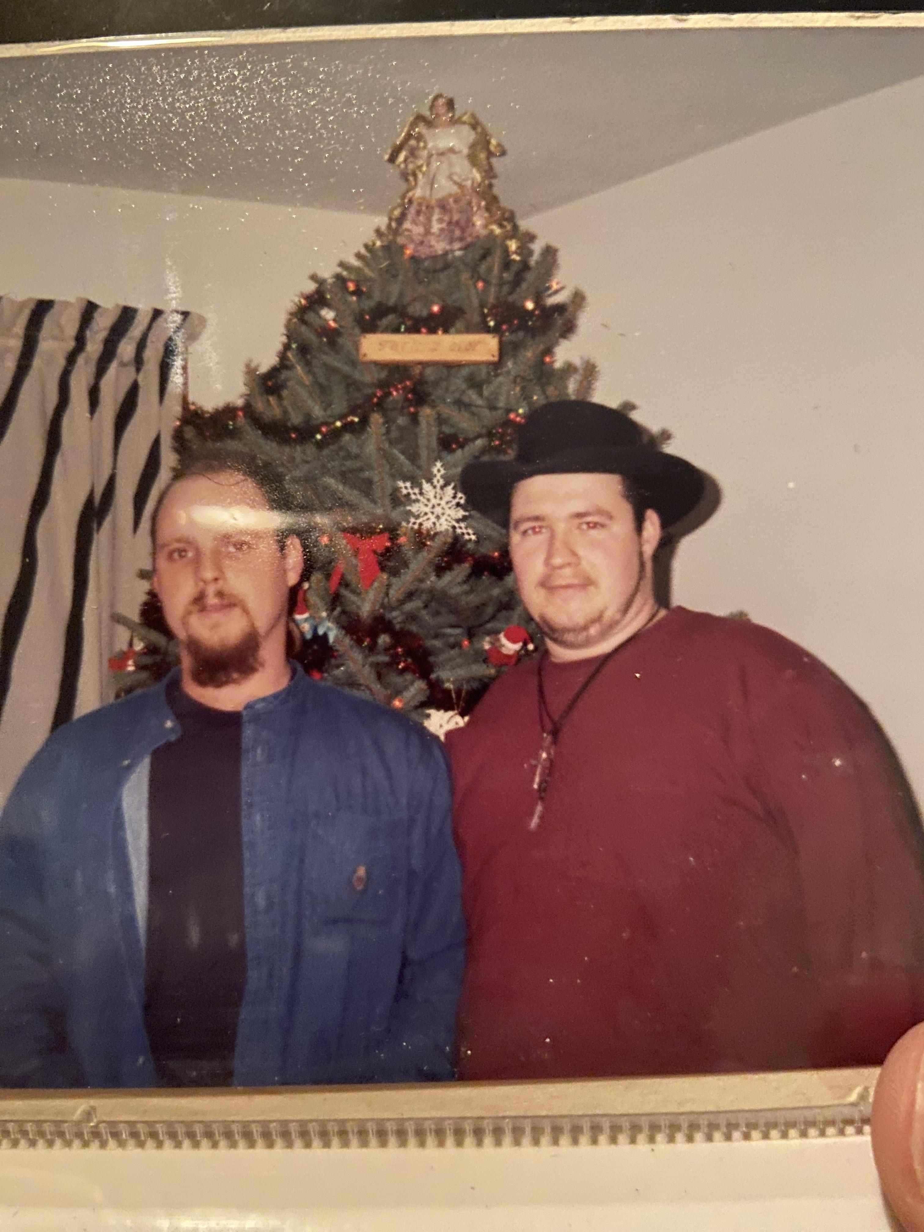Two men standing in front of a christmas tree