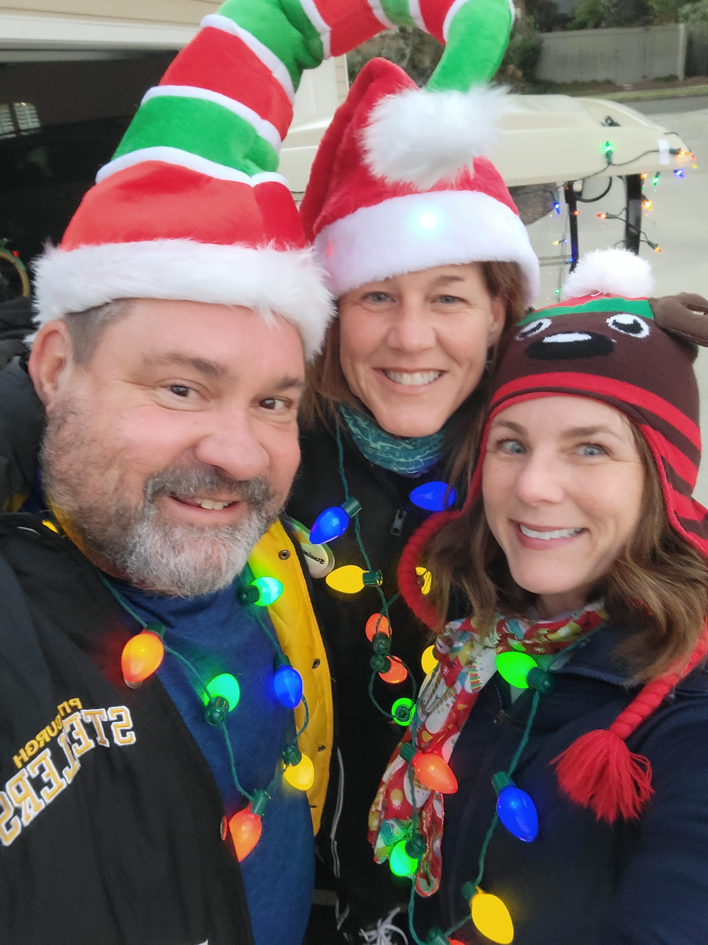 A group of people wearing christmas hats and smiling