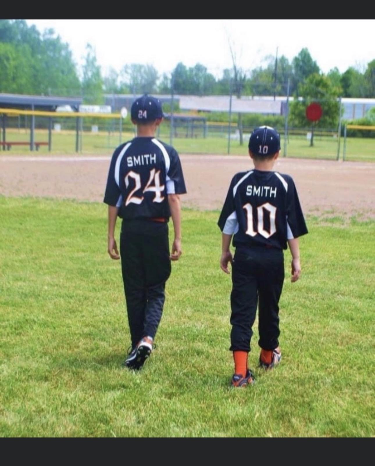 A couple of young boys wearing baseball uniforms