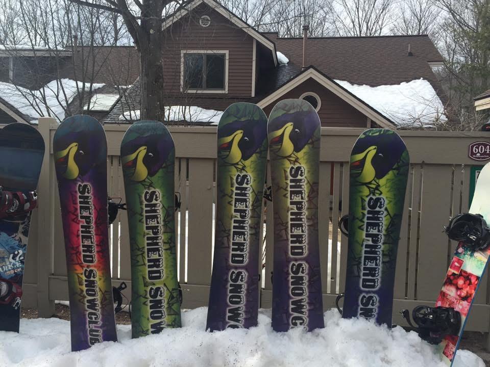 A row of snowboards in the snow