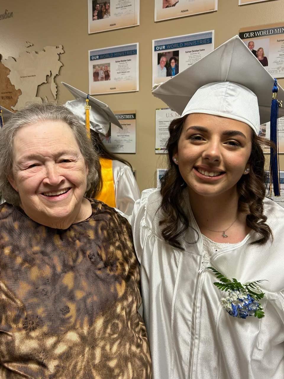 A woman and a young woman in graduation gowns