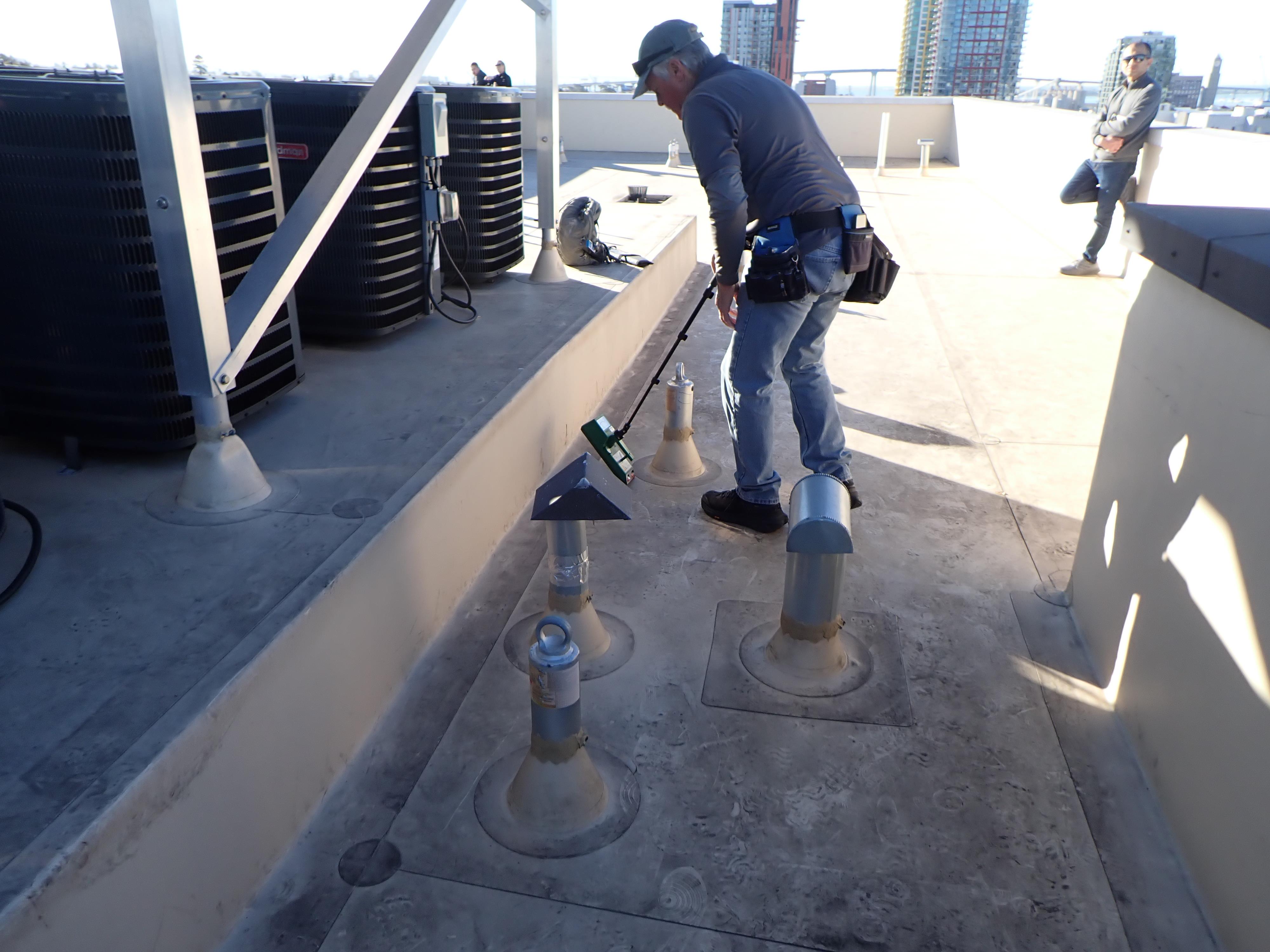 A man holding a tool next to a metal object