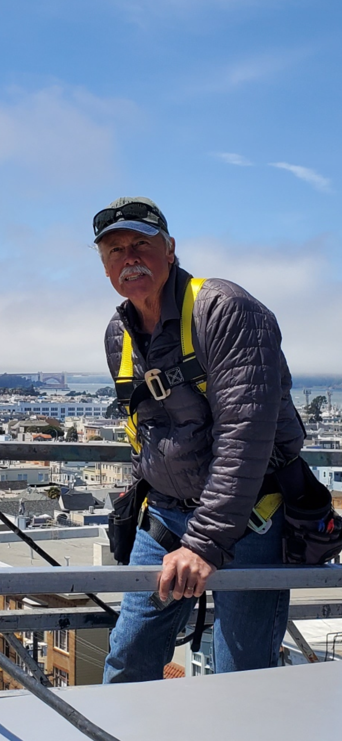 A man standing on a railing with a city in the background
