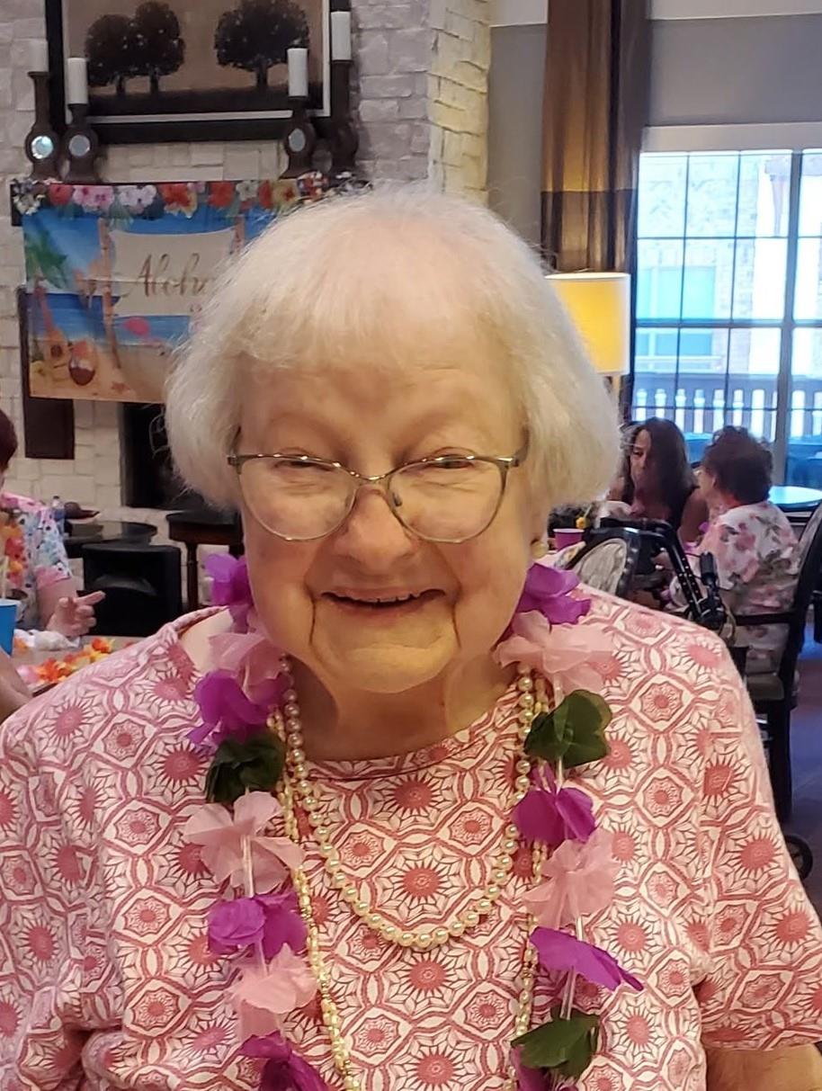 A woman wearing a necklace and a flower necklace