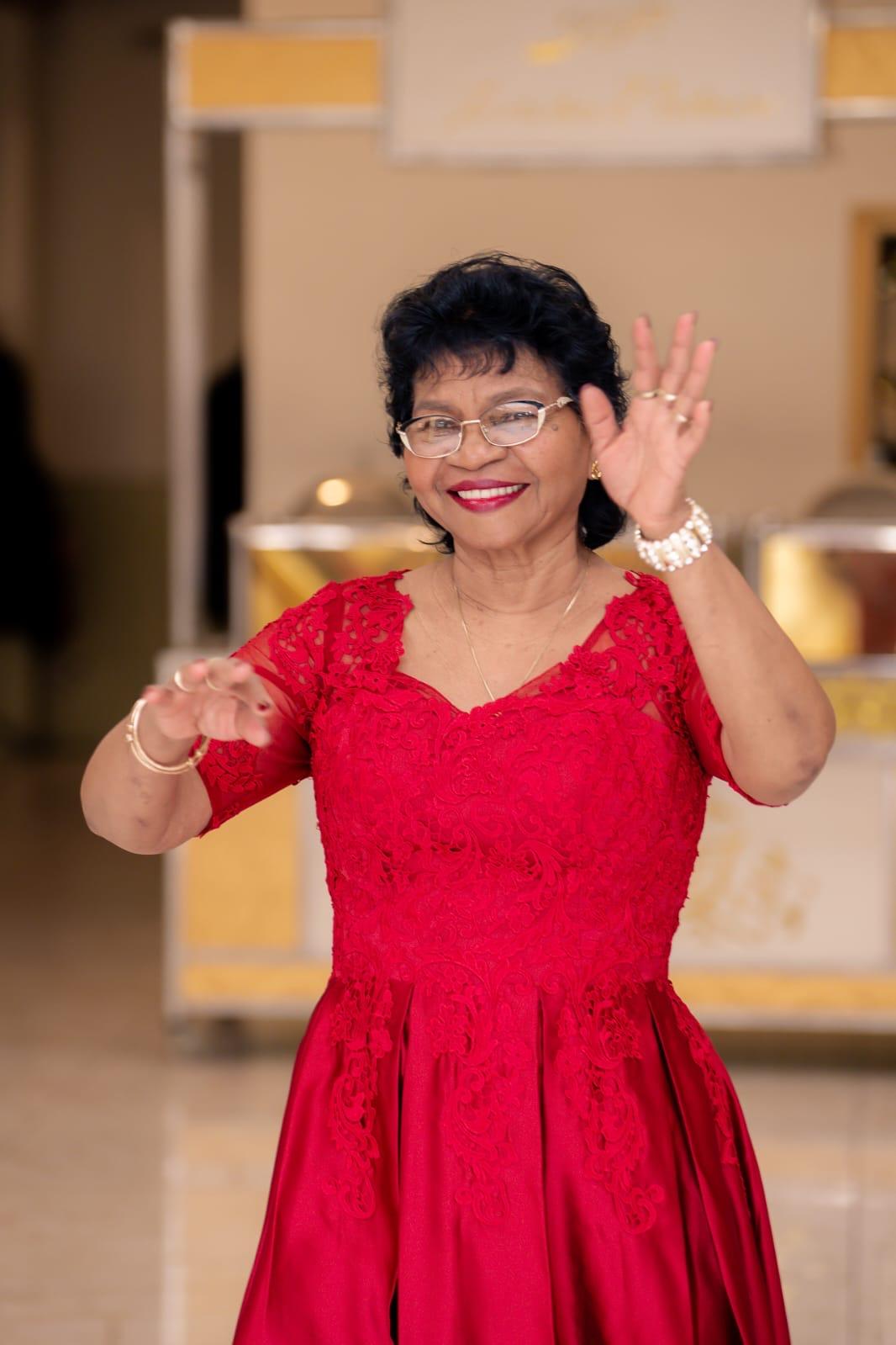 A woman in a red dress waving