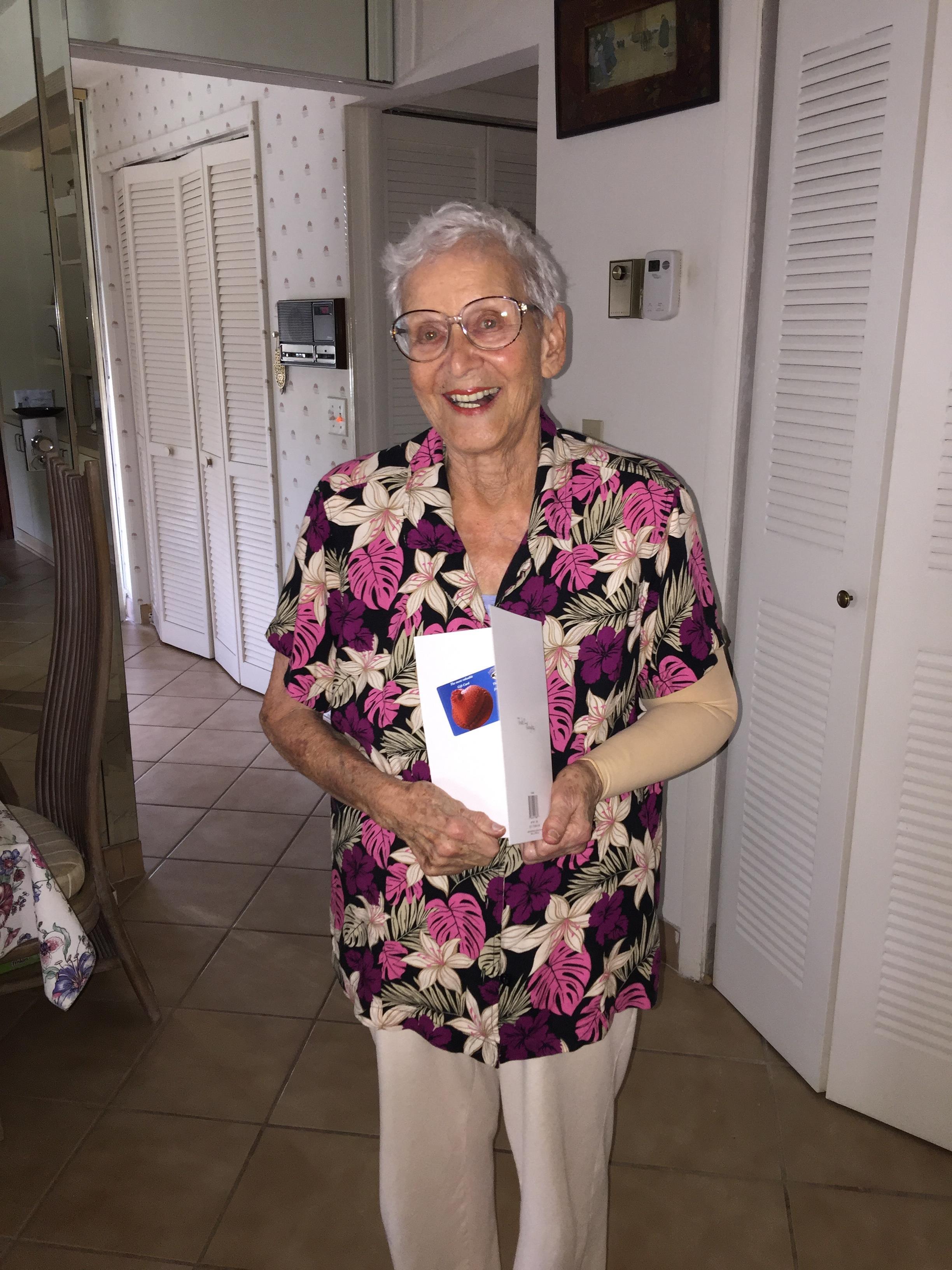 An older woman holding a box