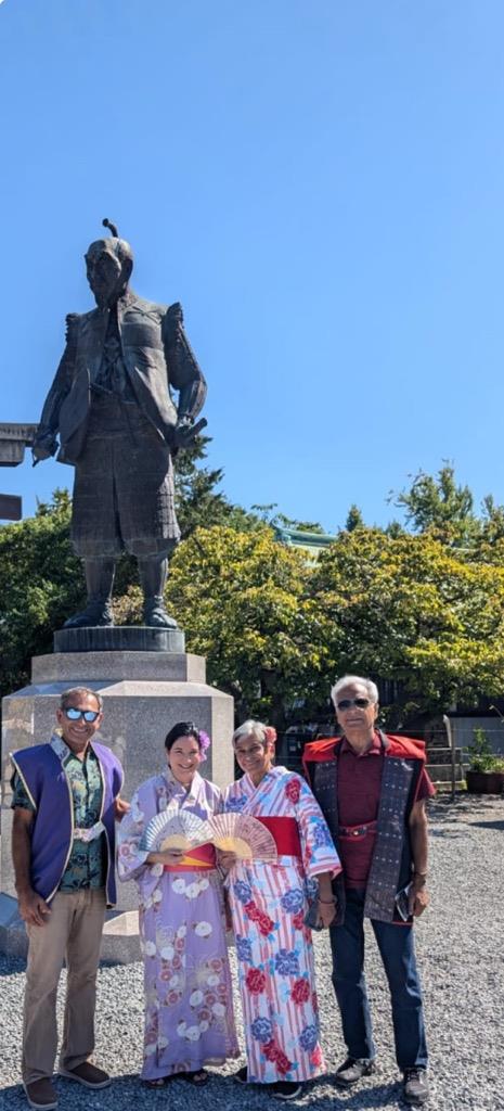 A group of people posing for a photo in front of a statue