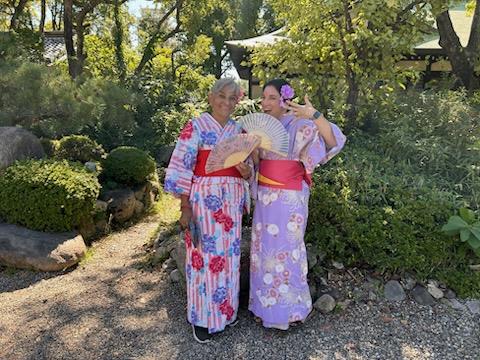 Two women in traditional dresses posing for a picture