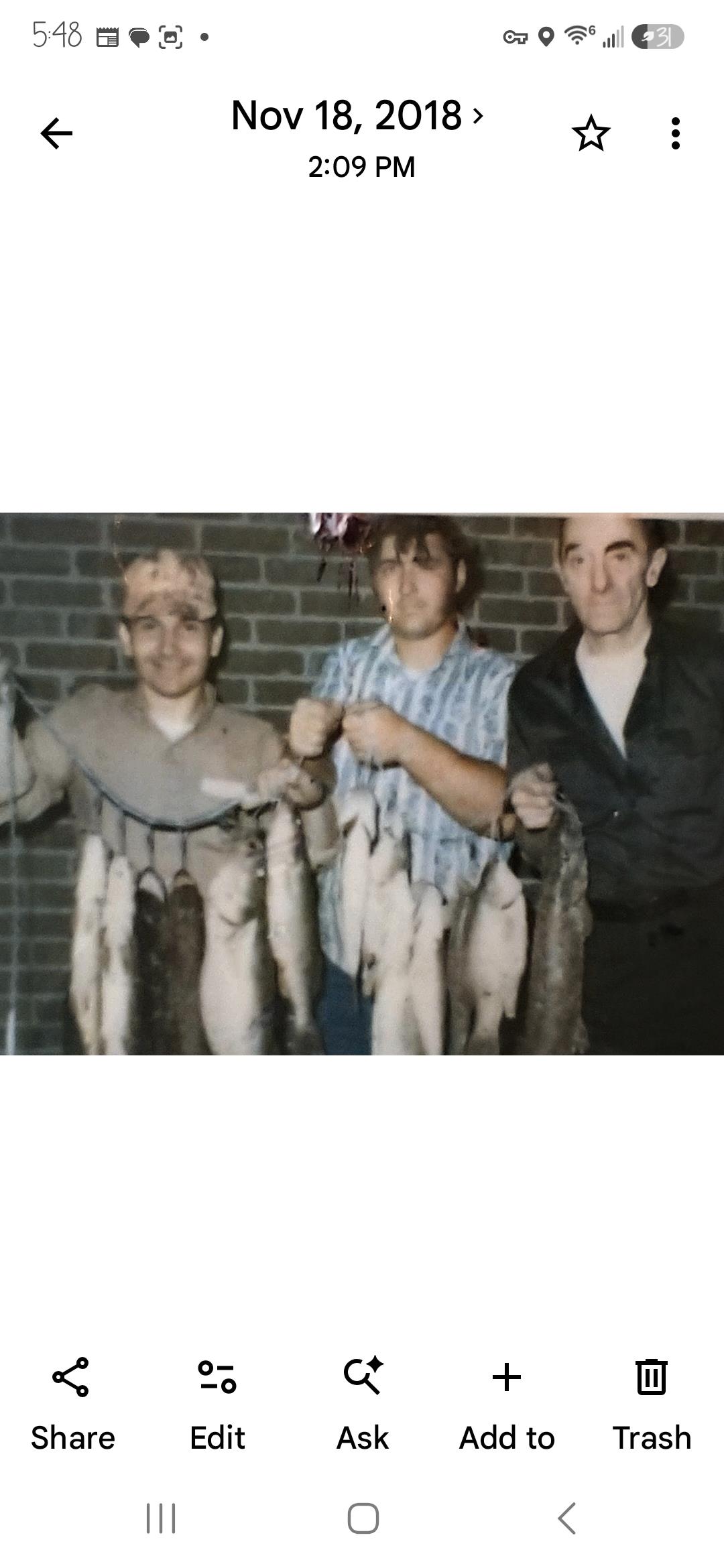 A group of men holding fish