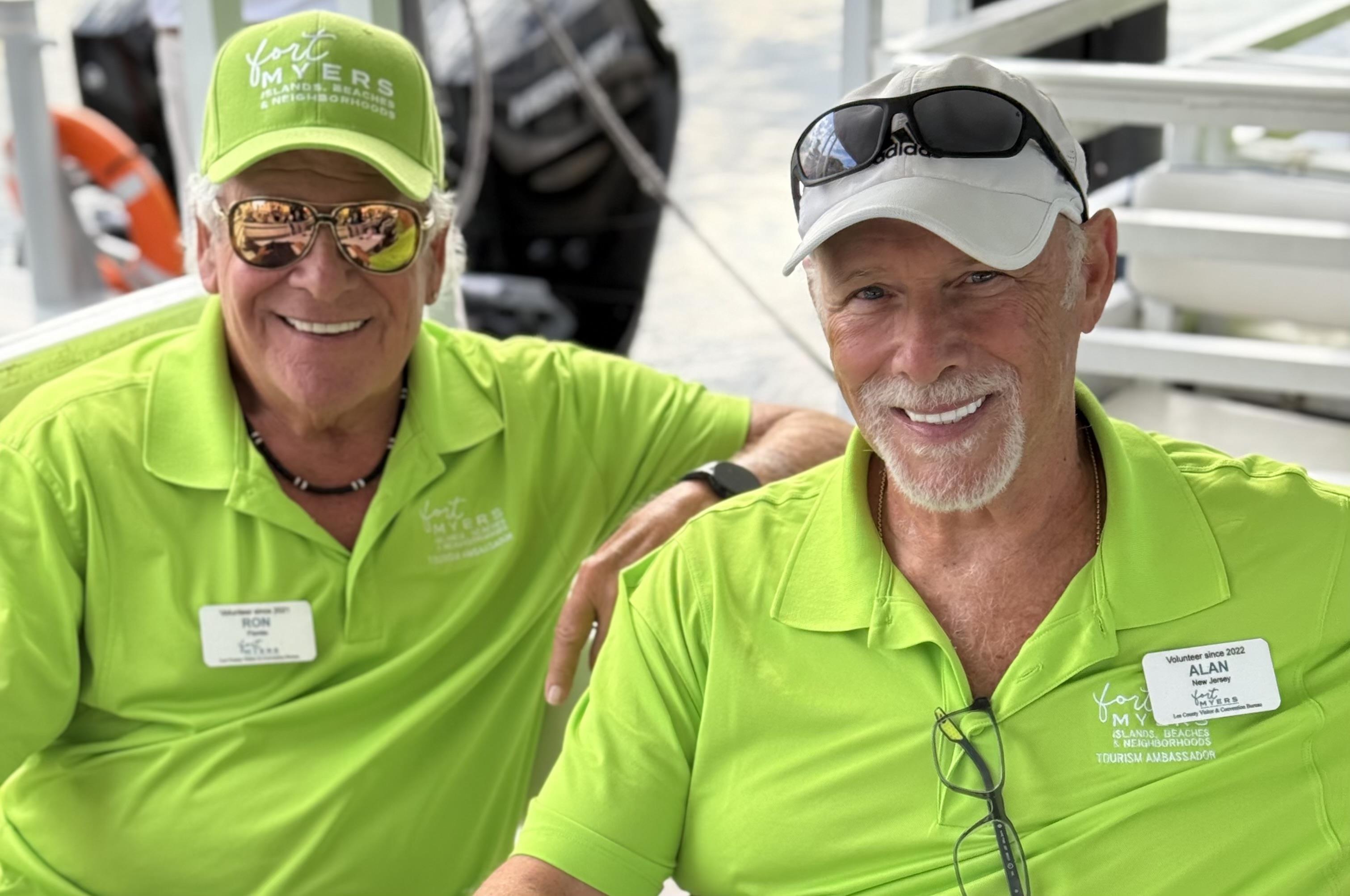 Two men wearing green shirts and sunglasses