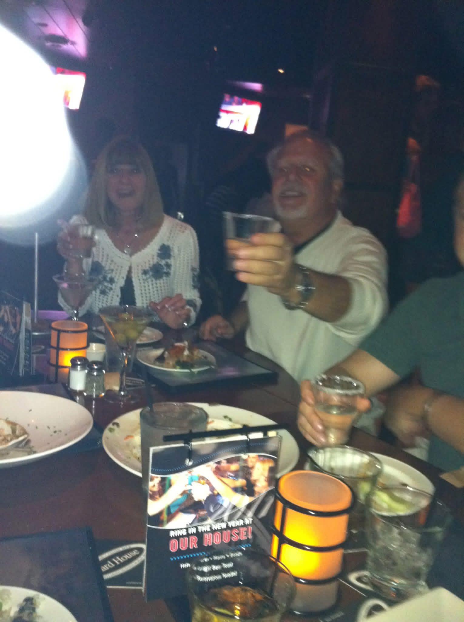 A group of people sitting at a table with plates of food and drinks