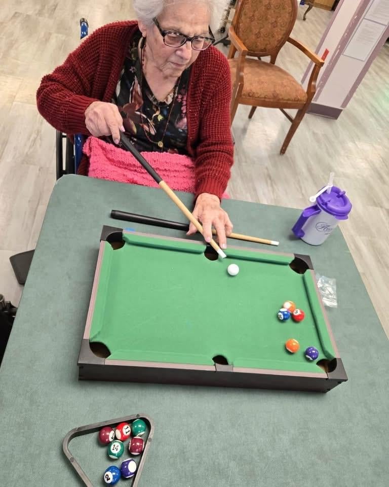 An old woman playing pool