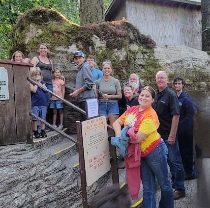 A group of people standing in front of a rock formation