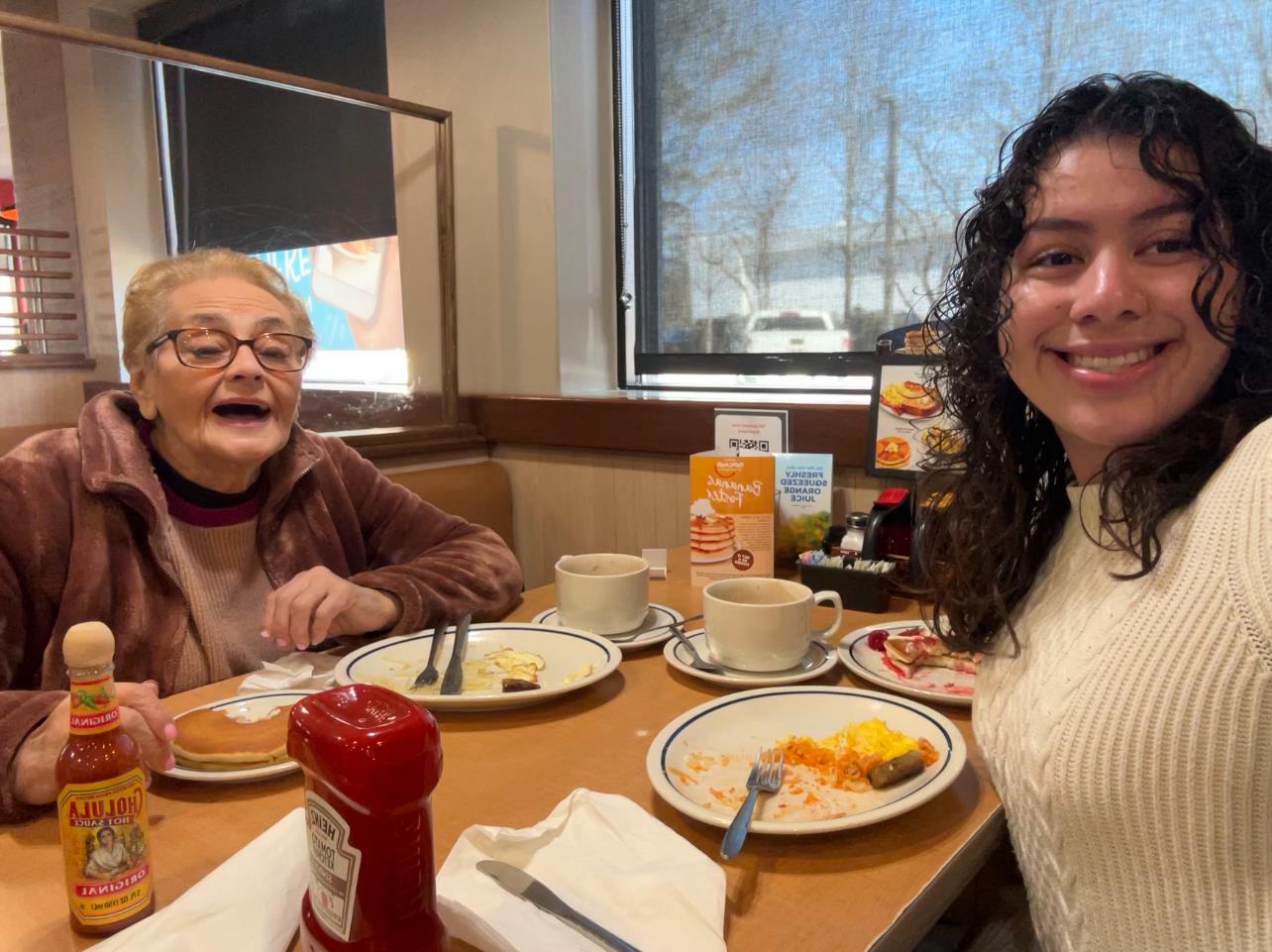 Two women sitting at a table with plates of food