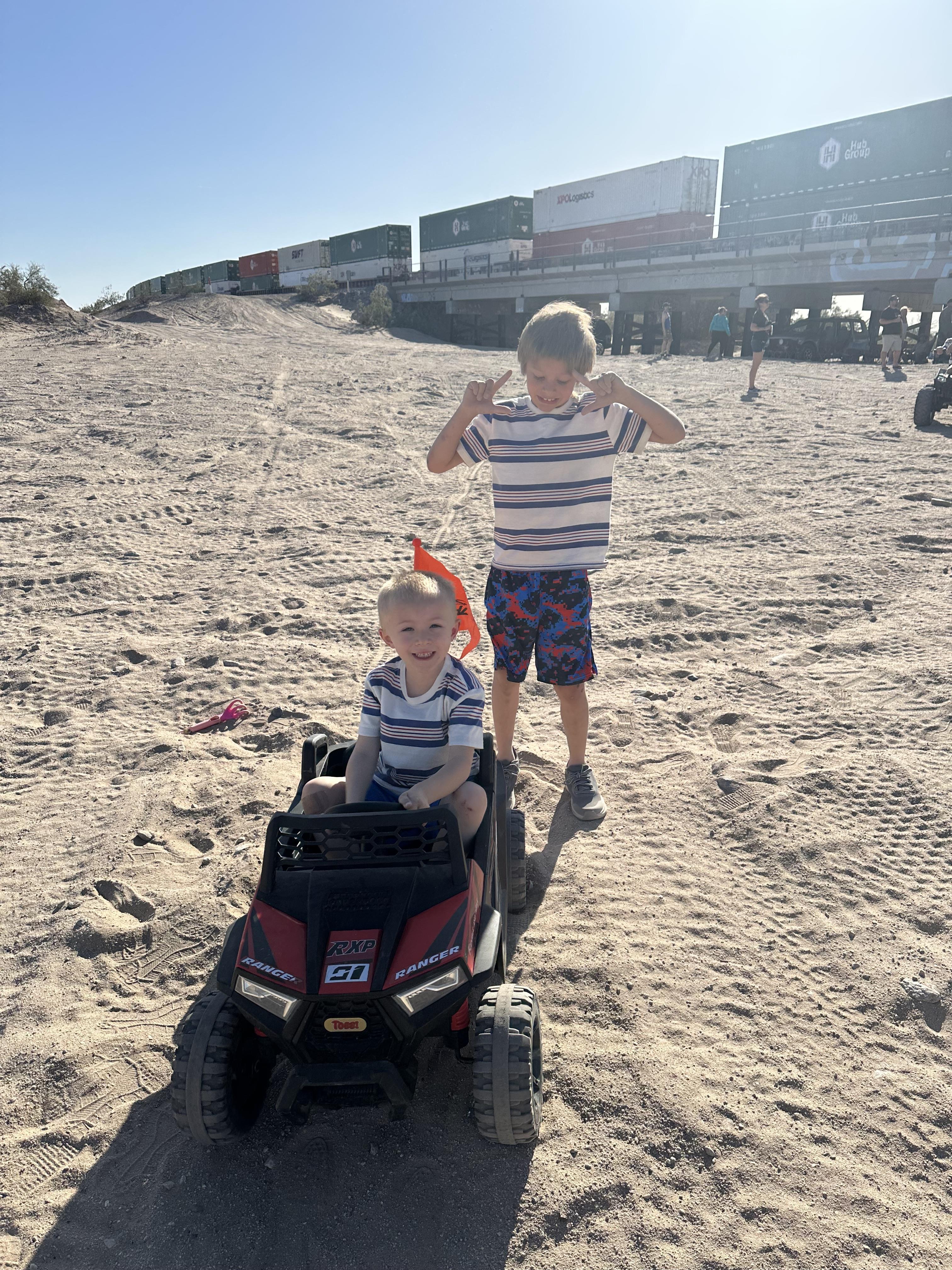 Two boys on a toy car