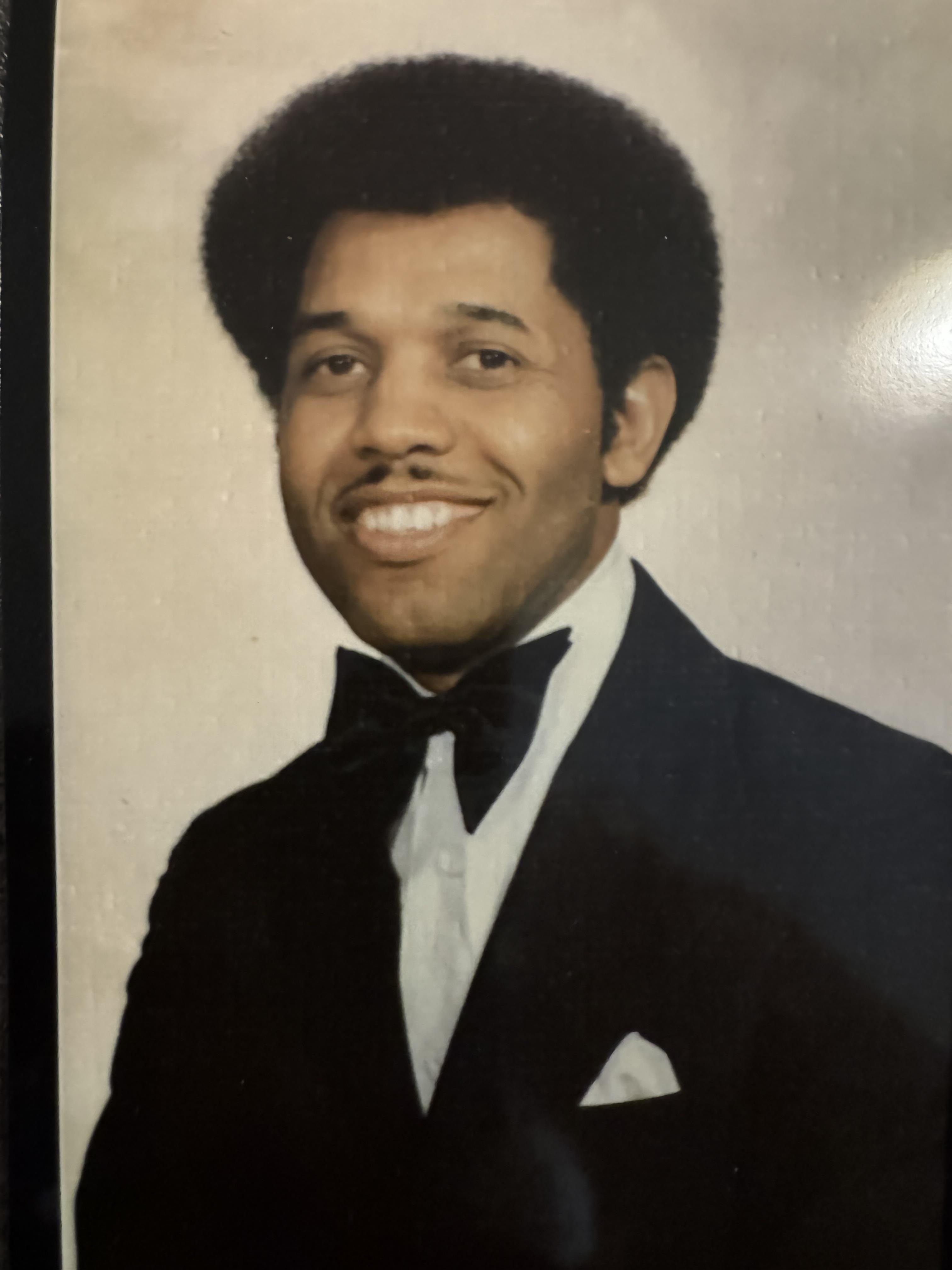 A man in a tuxedo smiling