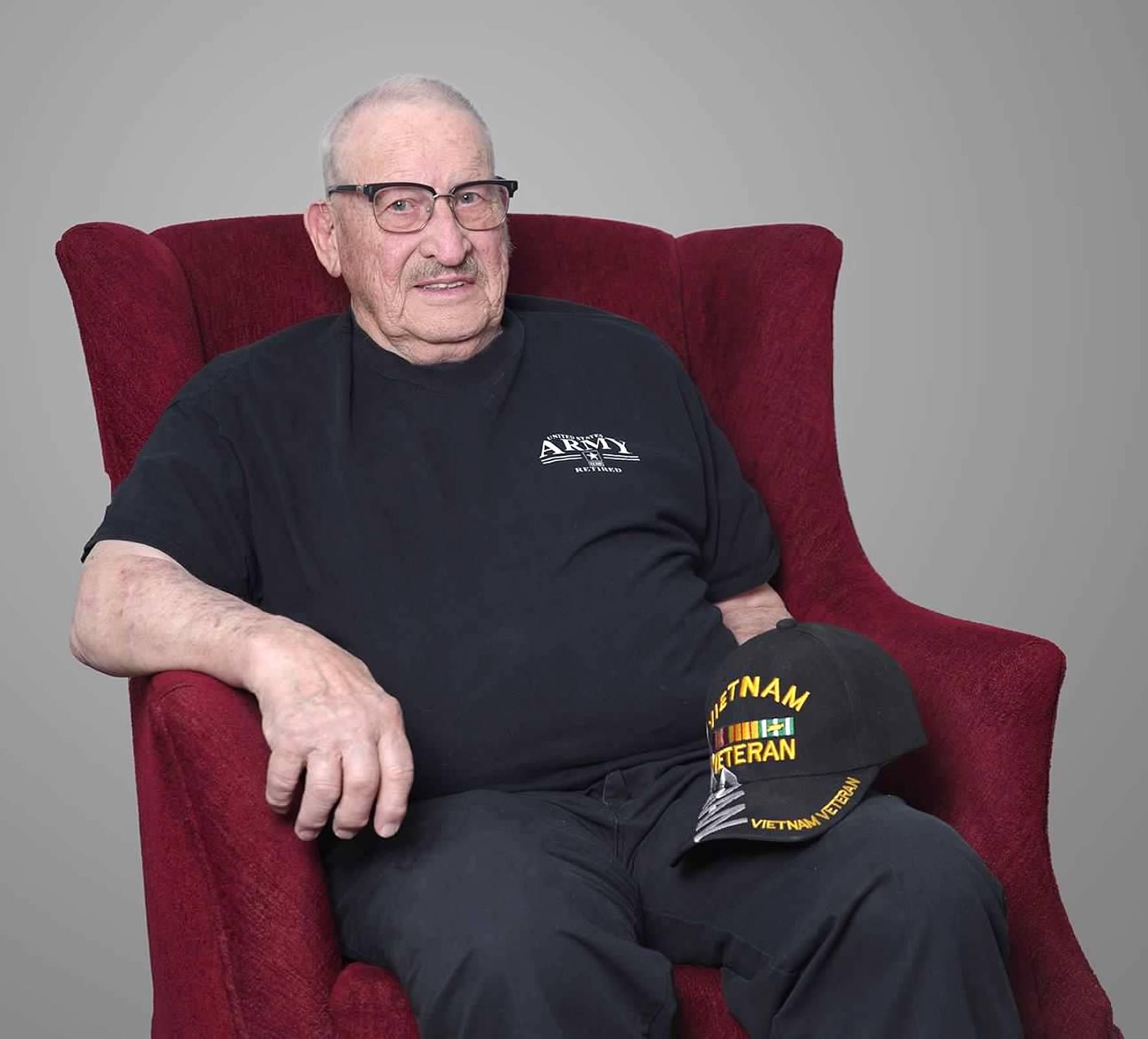 An old man sitting in a red chair