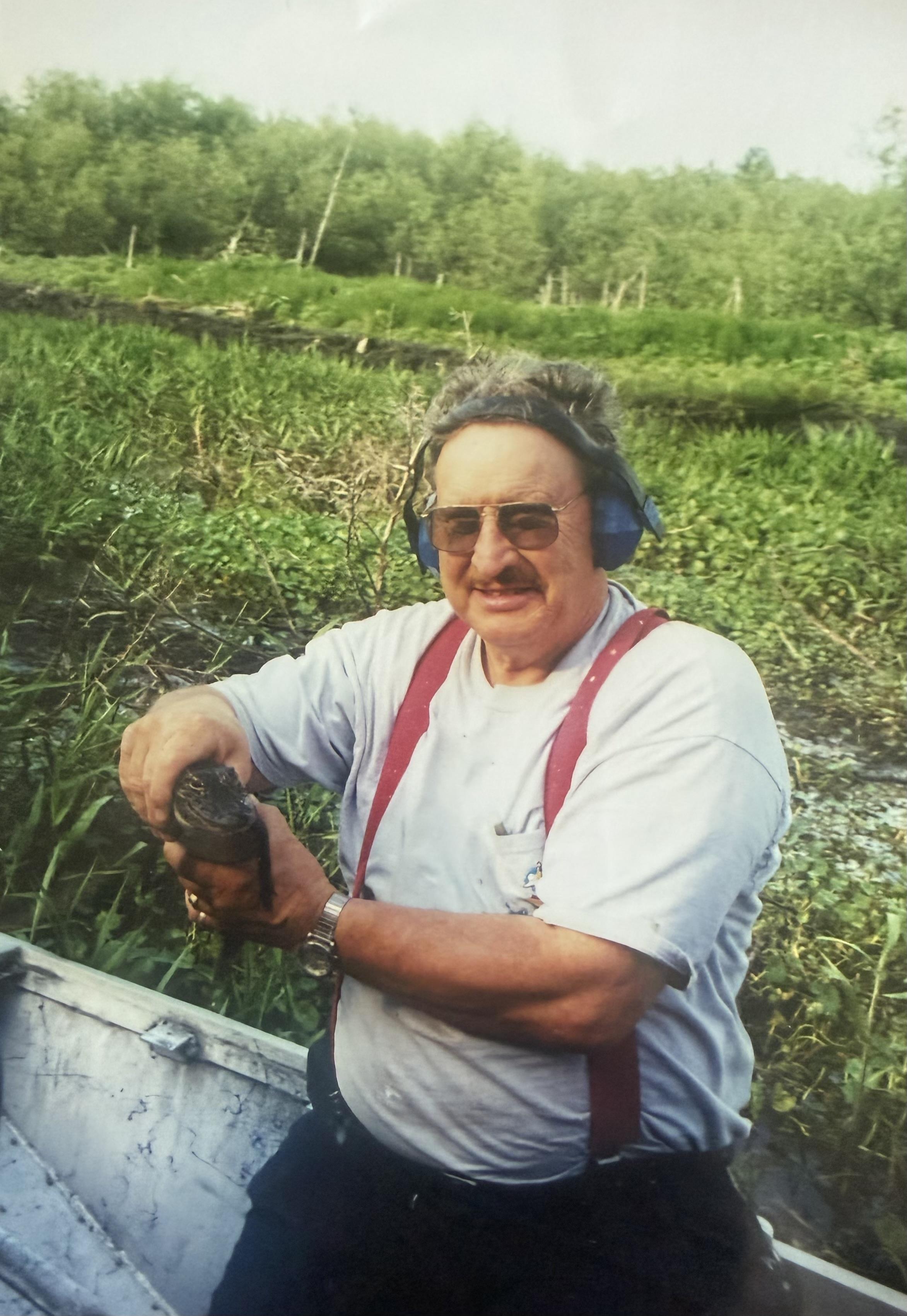 A man wearing headphones and holding a drill