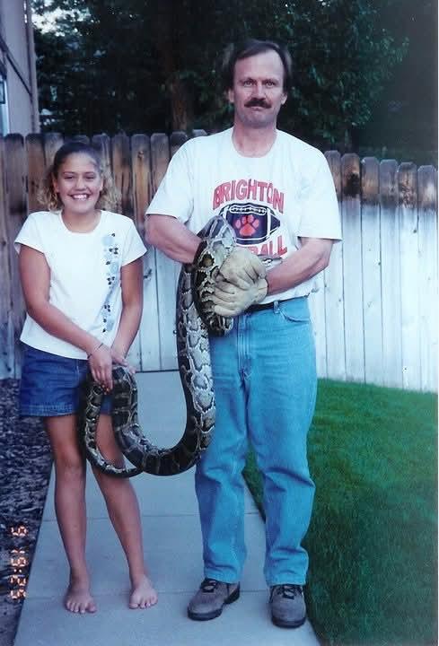 A man and girl holding a snake