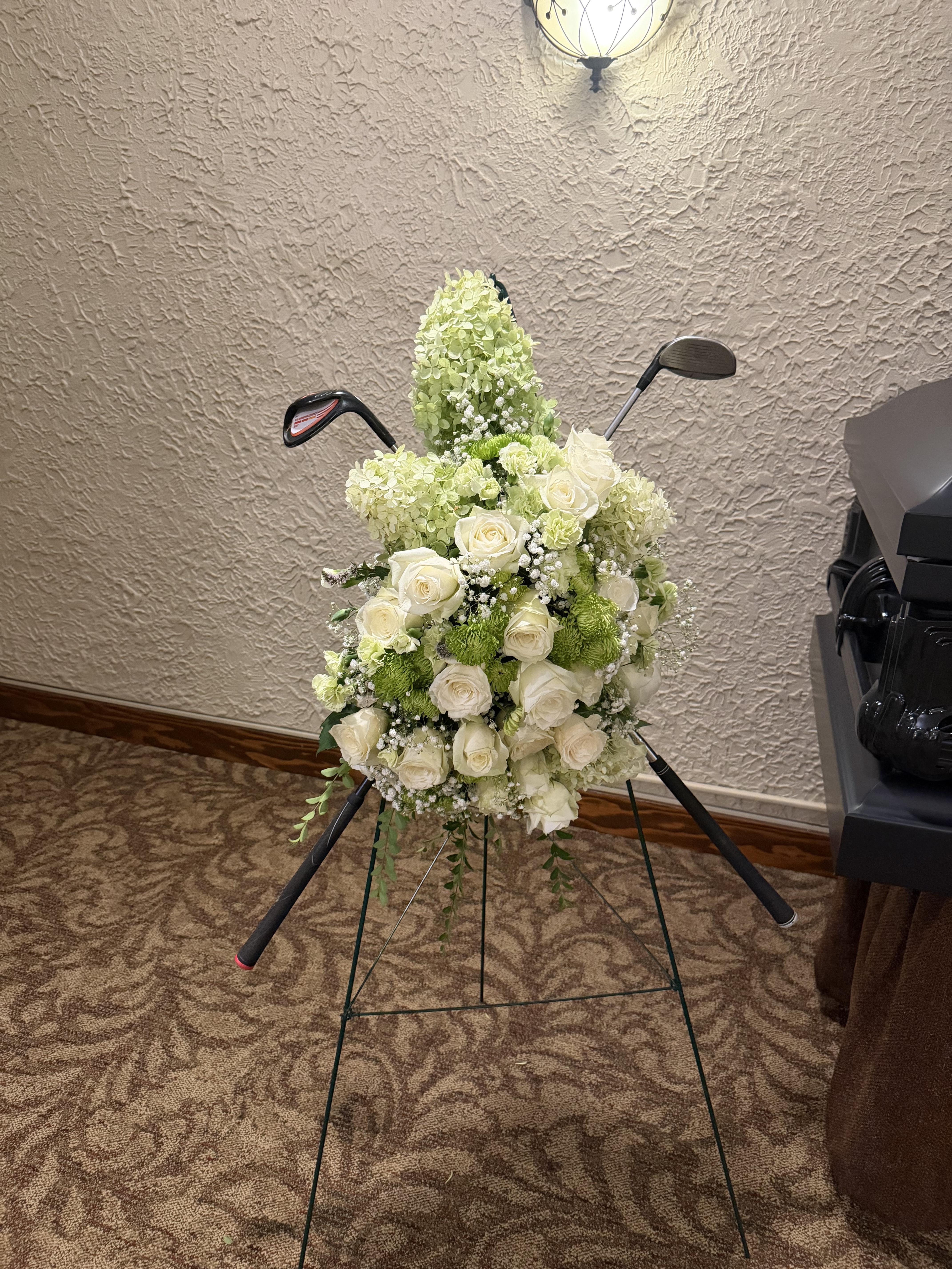 A bouquet of flowers and golf clubs on a stand