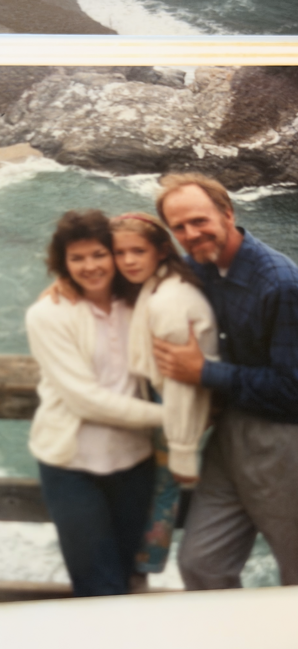 A man and woman with a girl posing for a picture