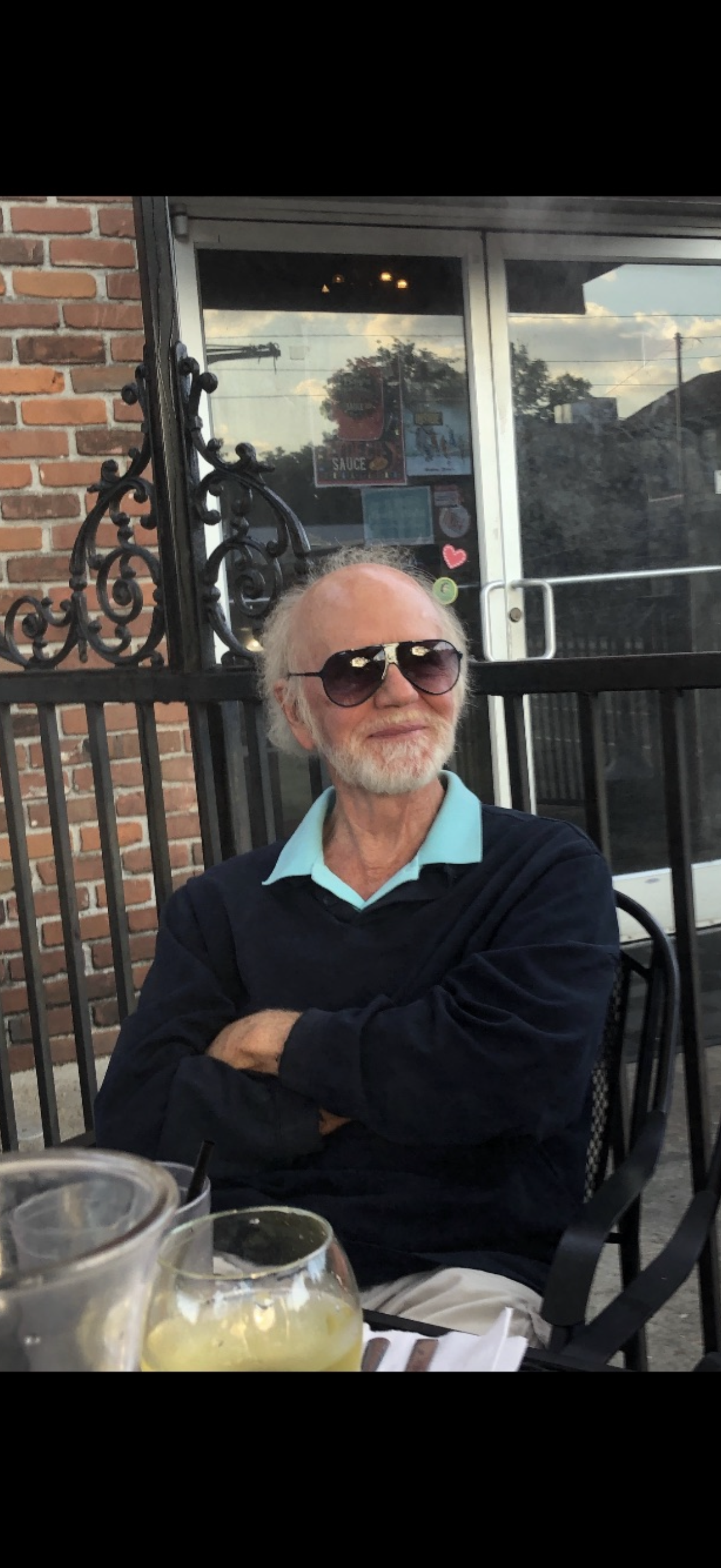 A man wearing sunglasses and sitting in a chair