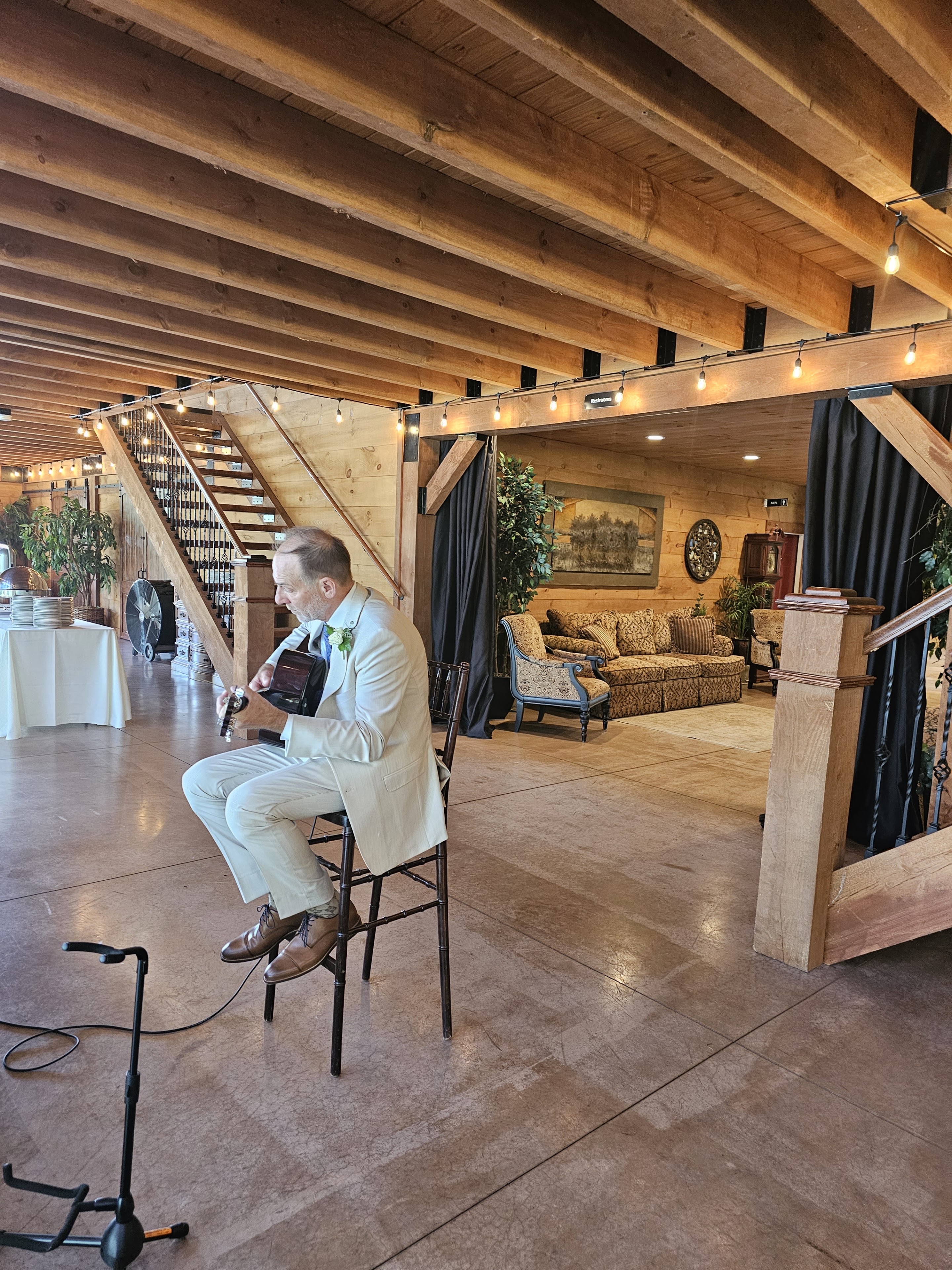 A man sitting on a chair playing a guitar