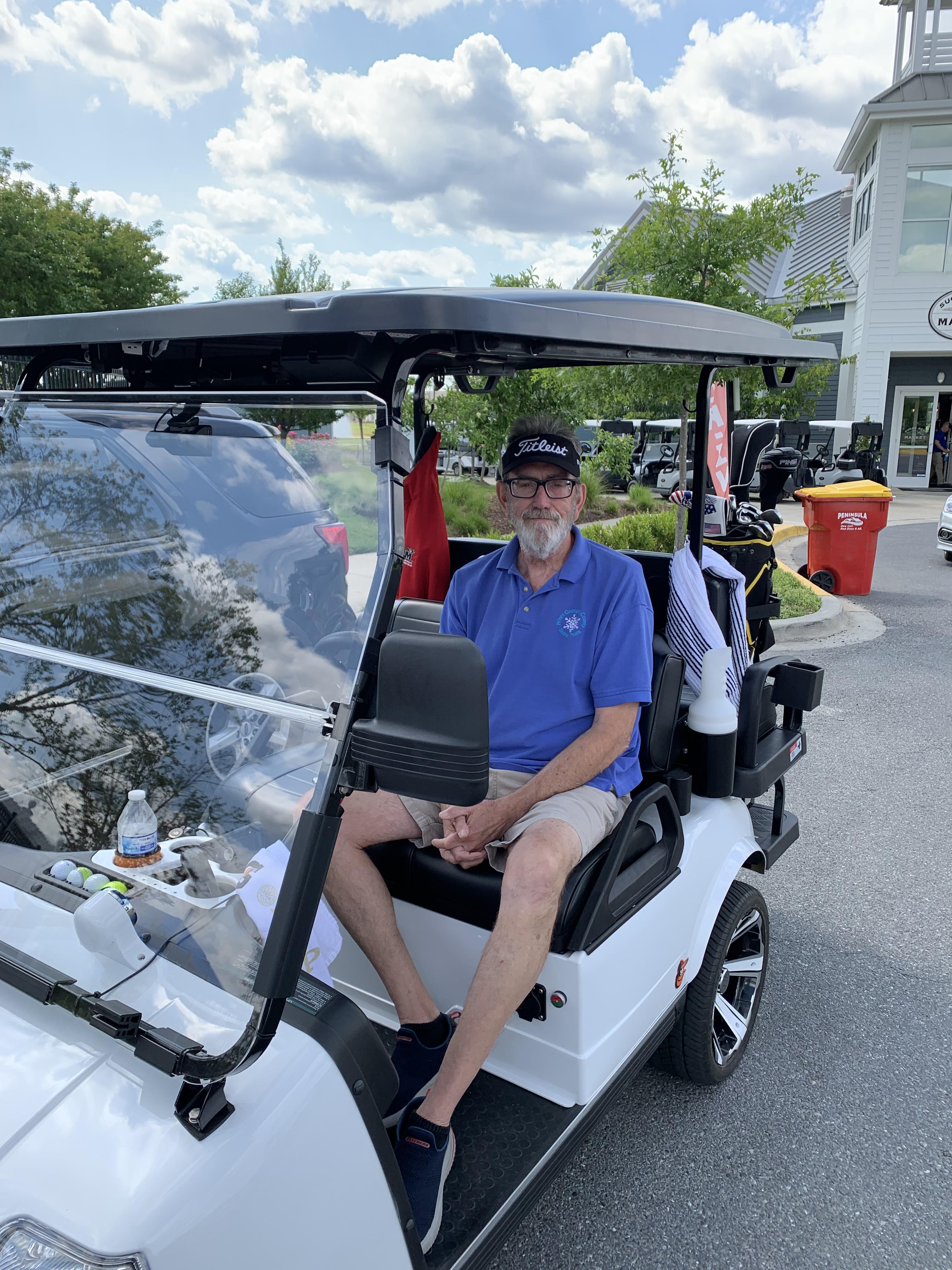 A man sitting in a golf cart