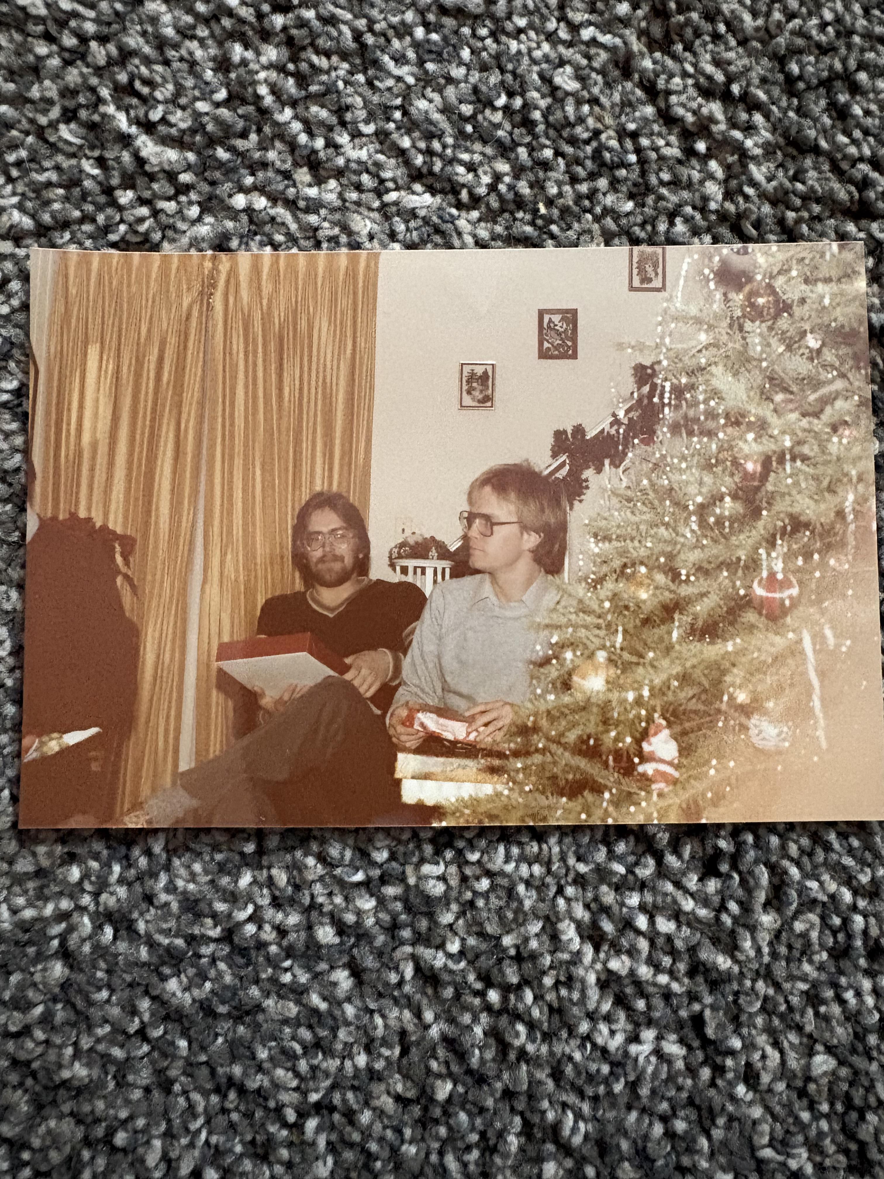 A group of men sitting in front of a christmas tree