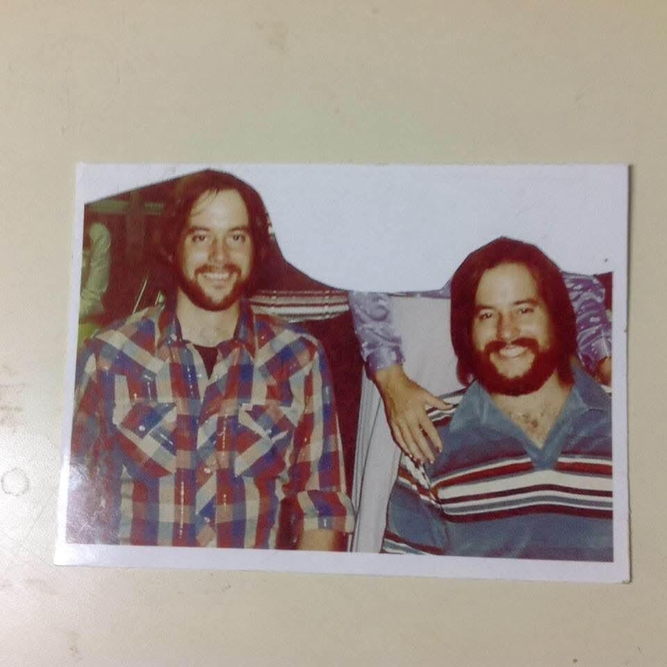 A man smiling next to another man