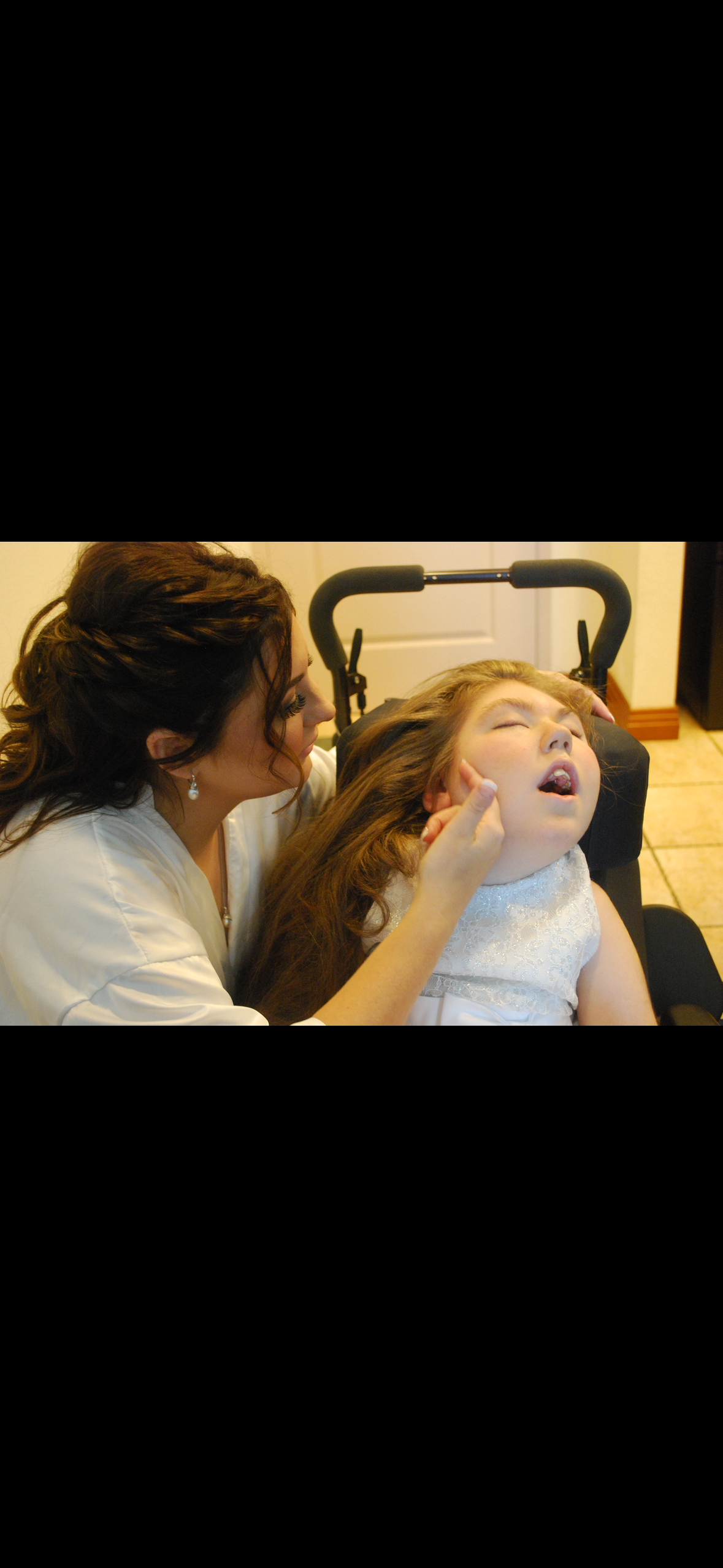 A woman touching a girl's ear