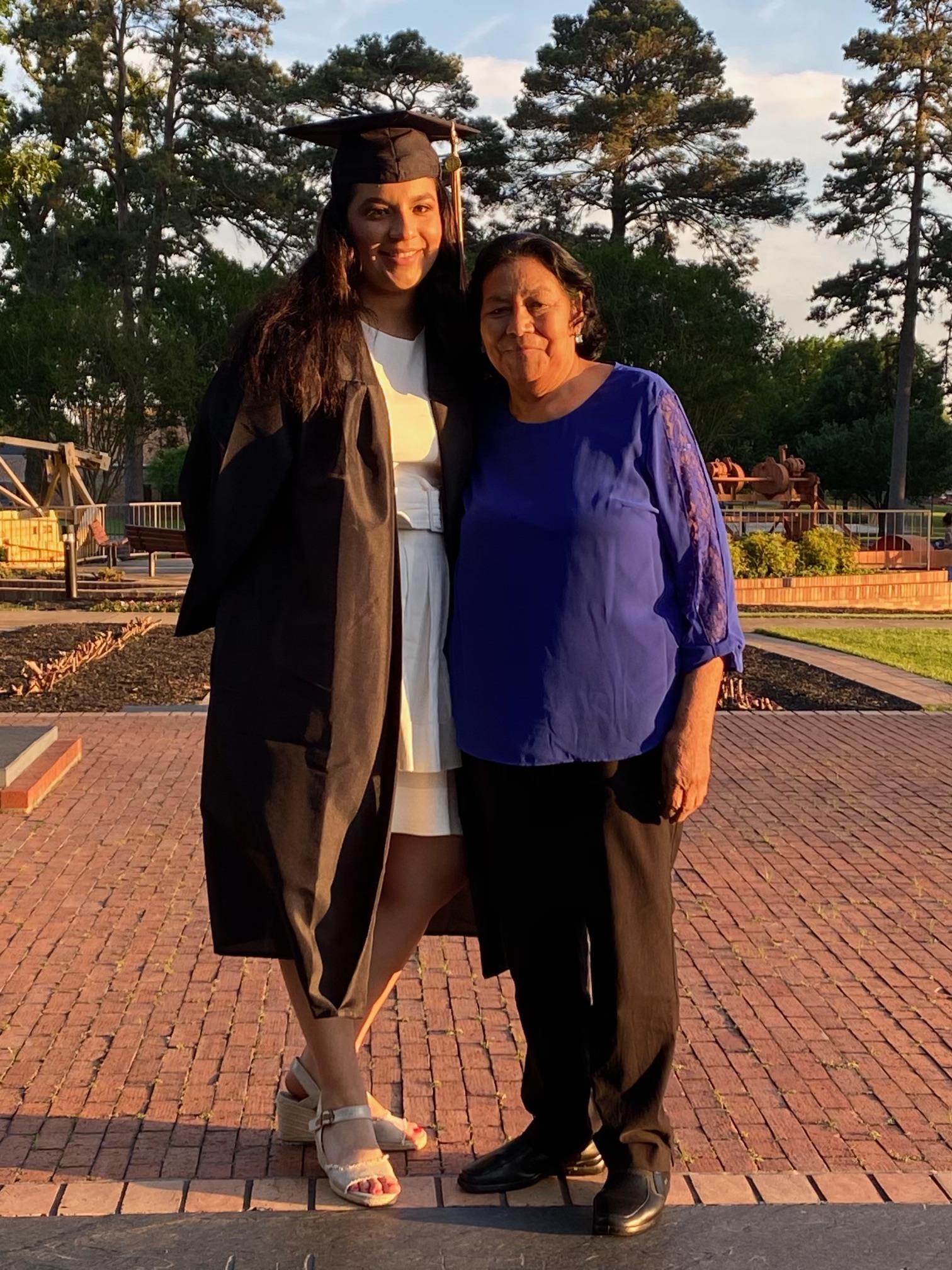 A woman standing next to a woman in a graduation cap