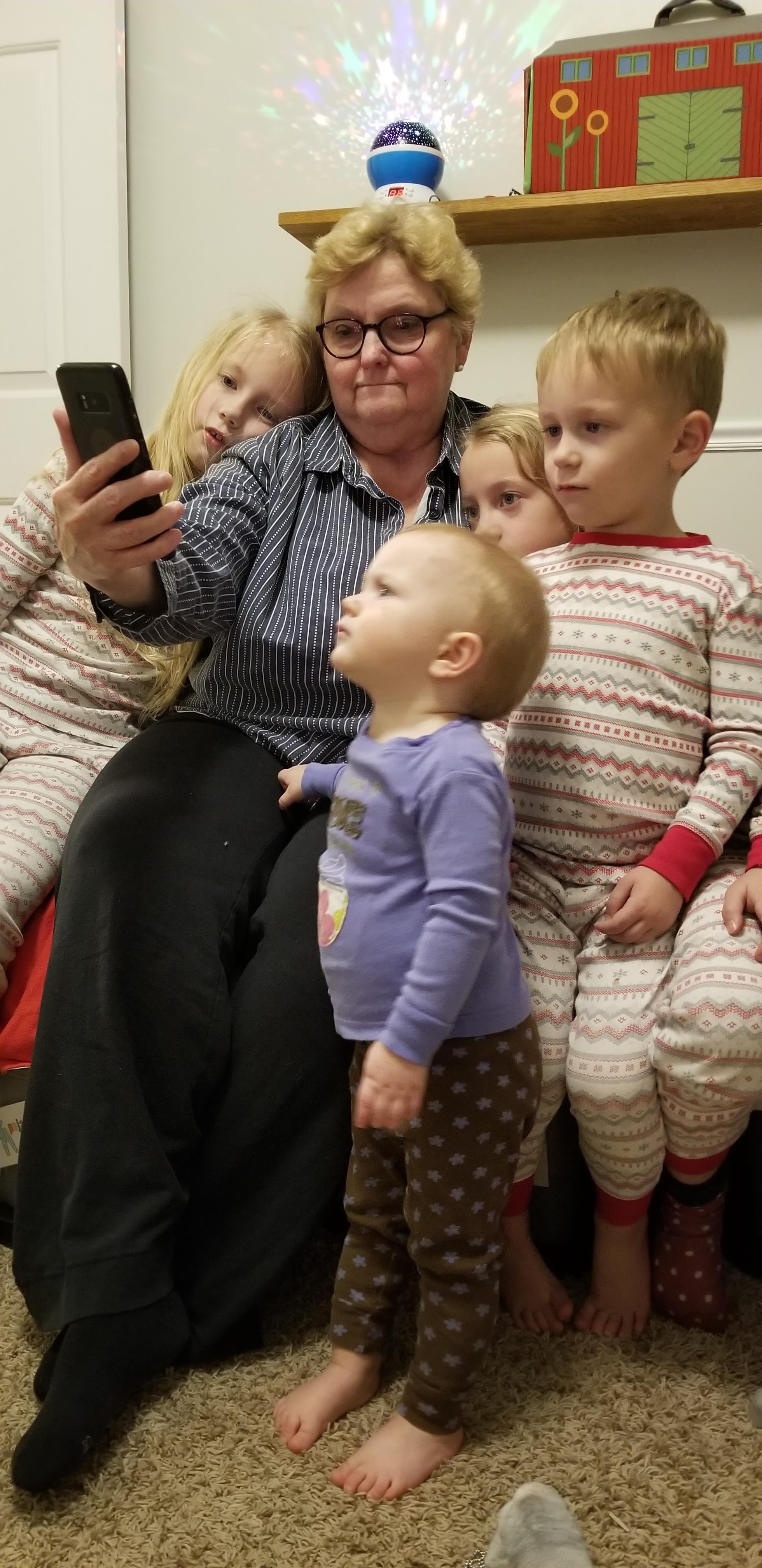 A woman taking a selfie with a group of children