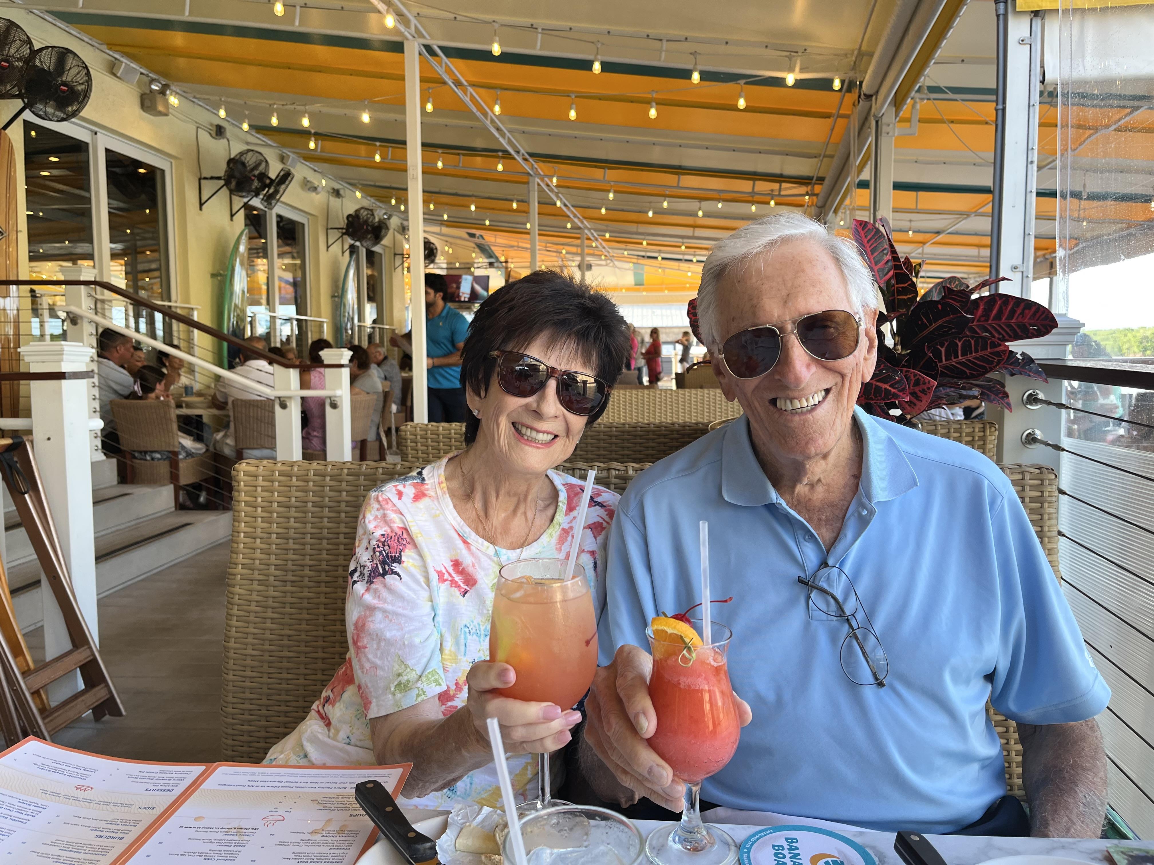 A man and woman sitting at a table with drinks