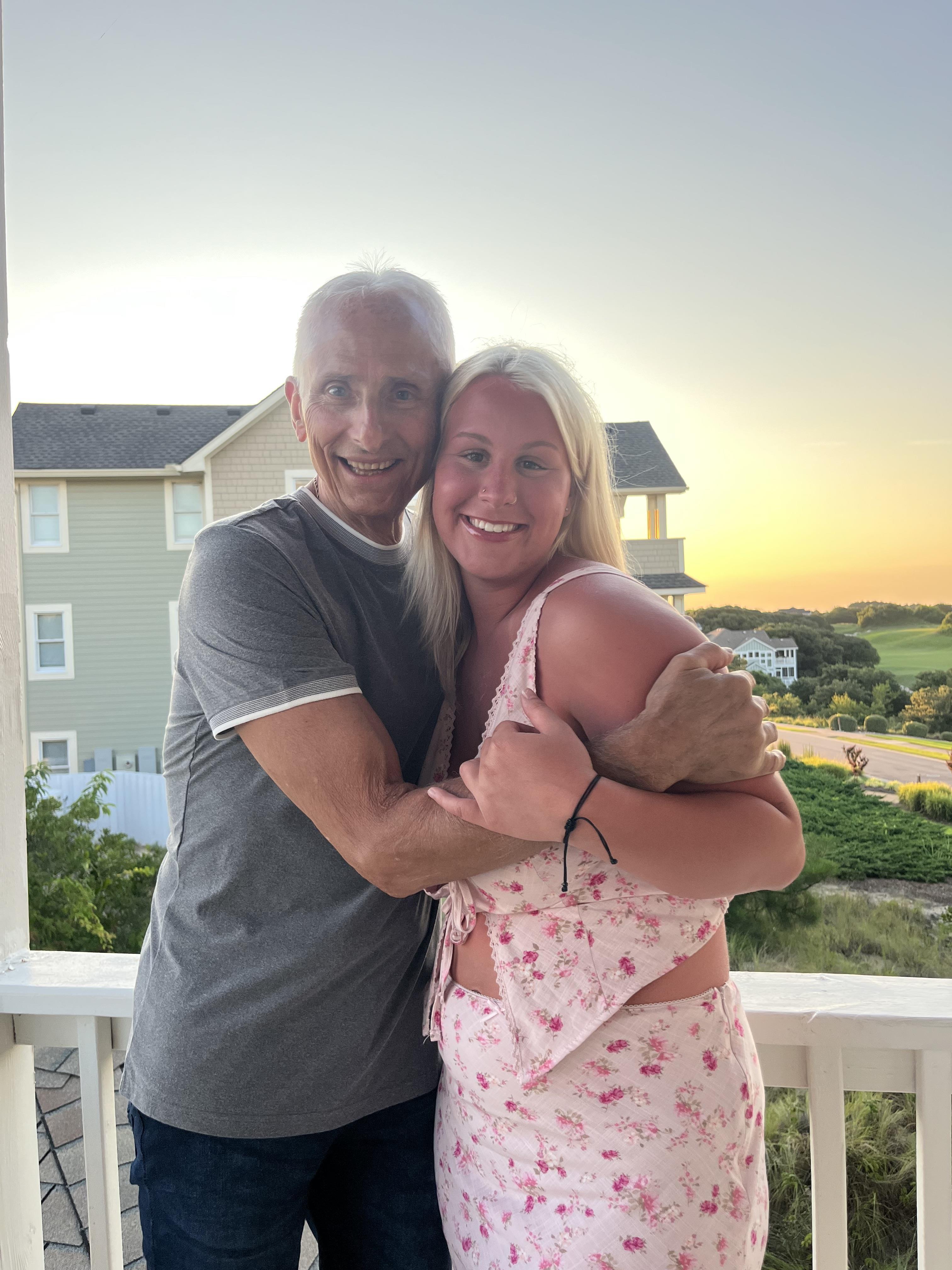 A man and woman hugging on a porch