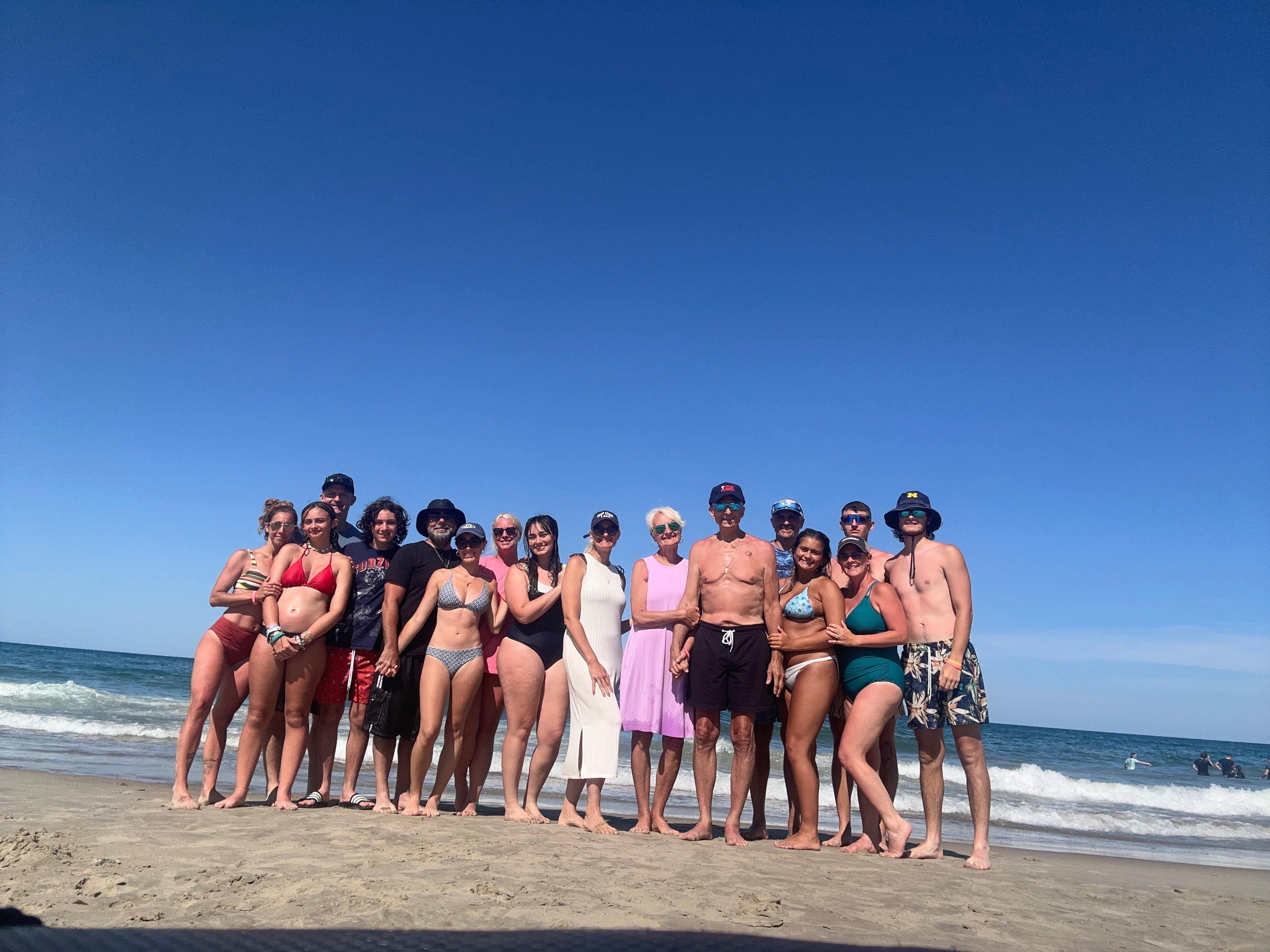 A group of people posing for a photo on a beach