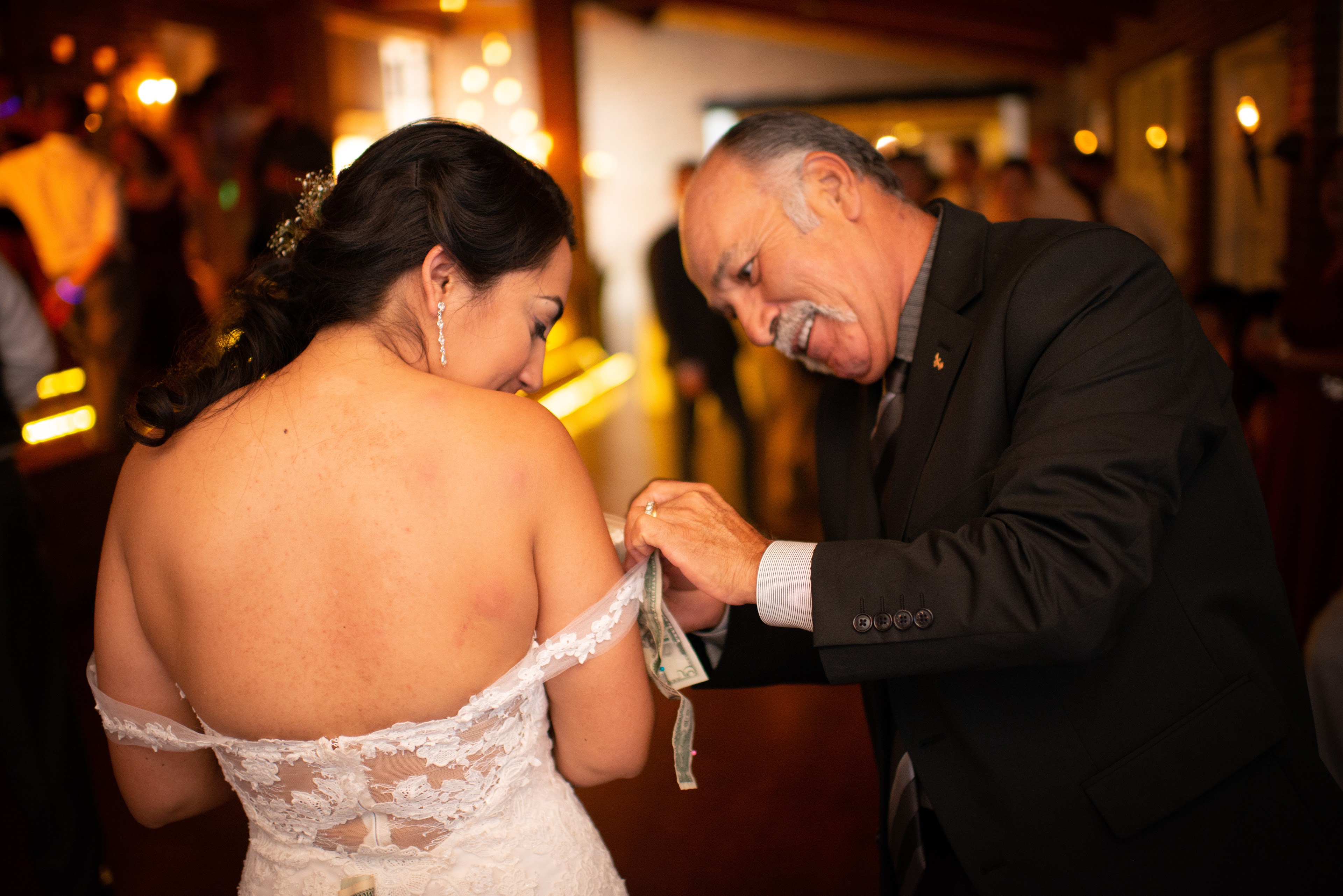 A man putting money on a woman's shoulder