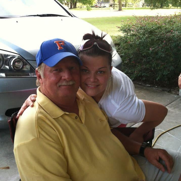 A man and woman sitting on a sidewalk