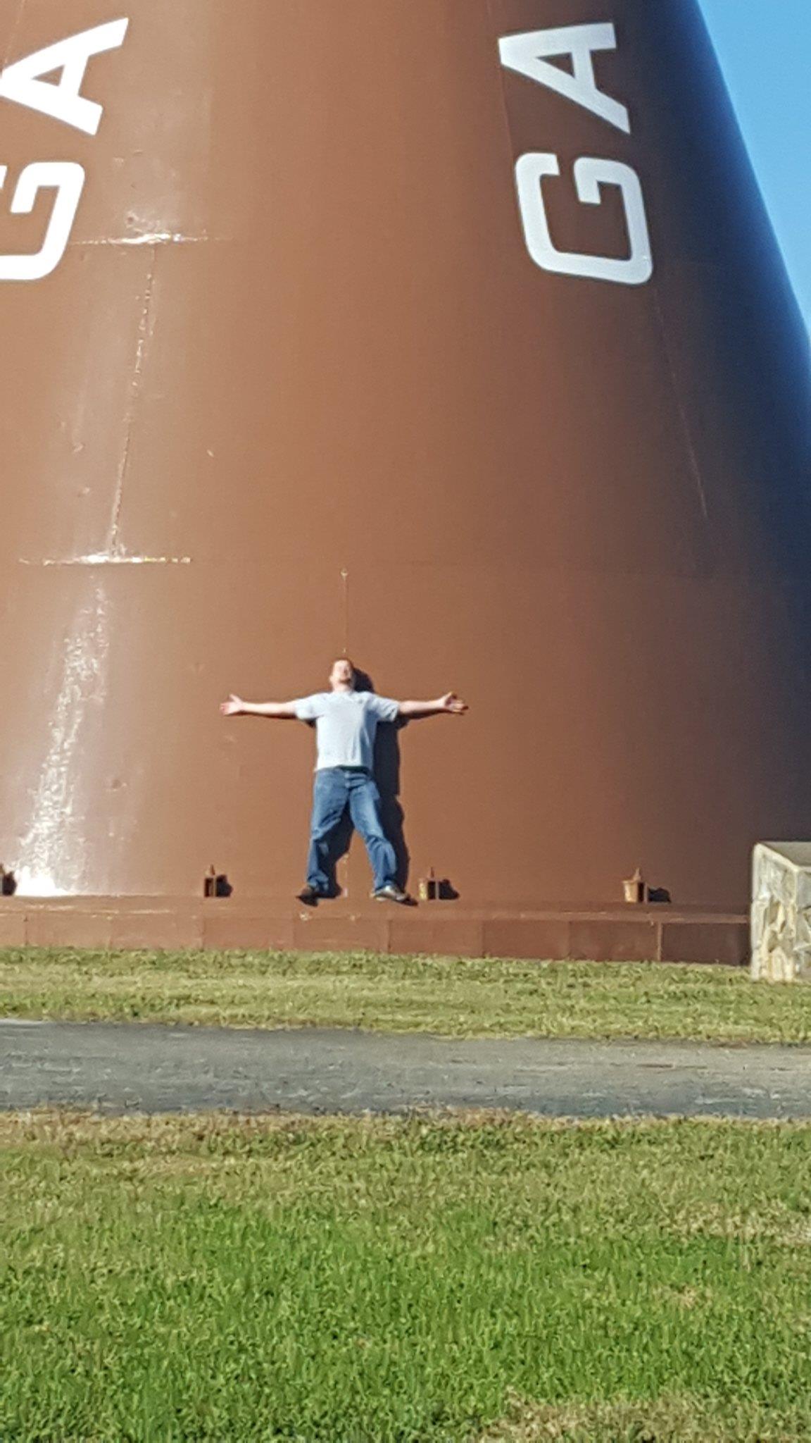 A man standing on a wall with arms outstretched