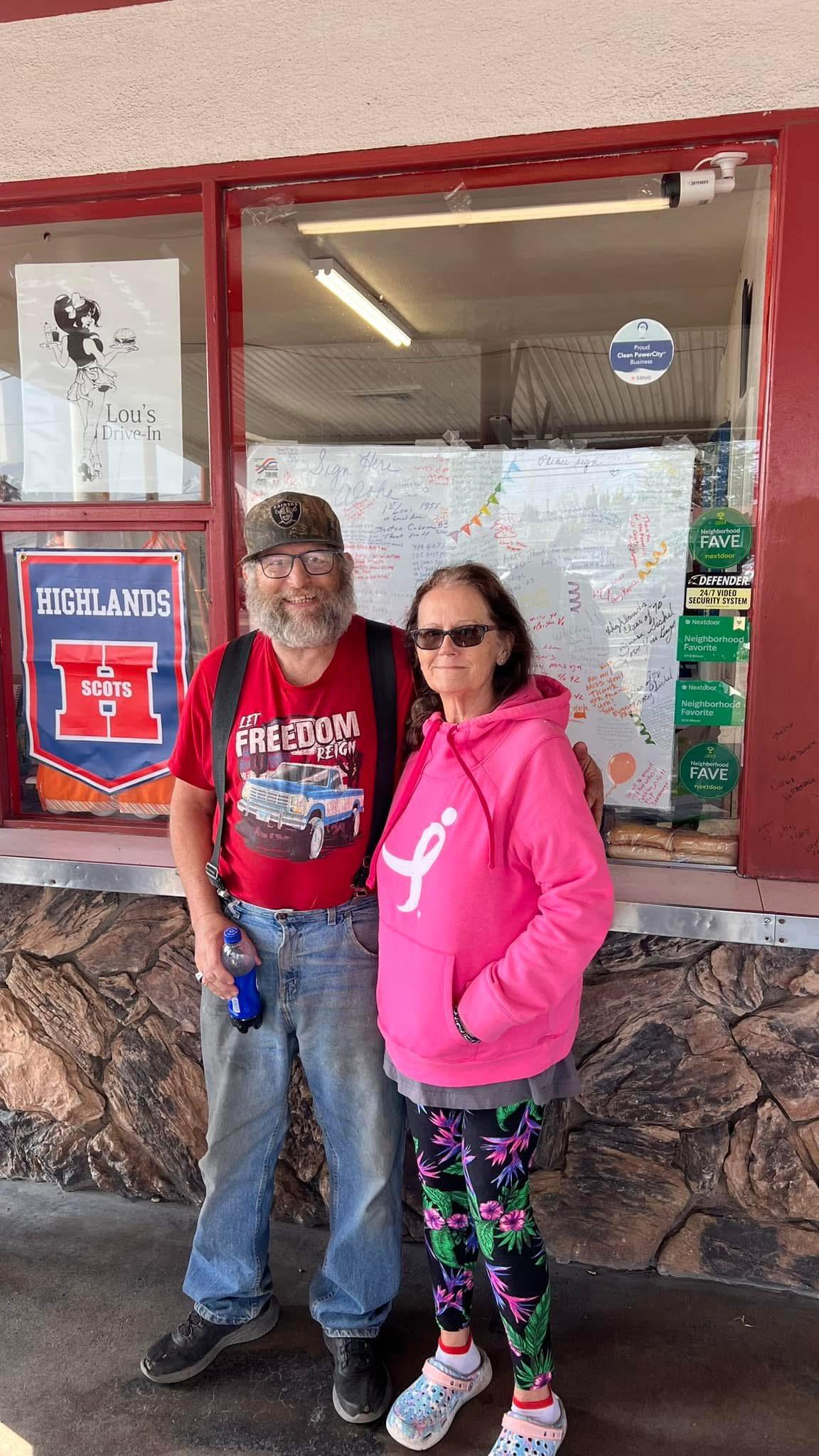 A man and woman standing in front of a store