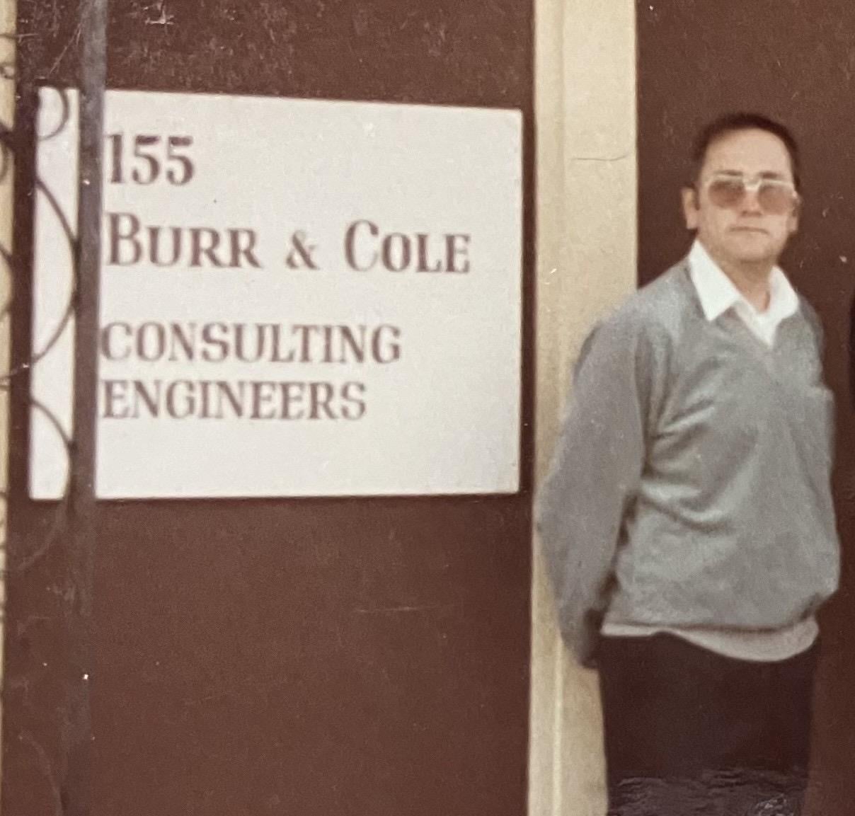 A man standing next to a sign