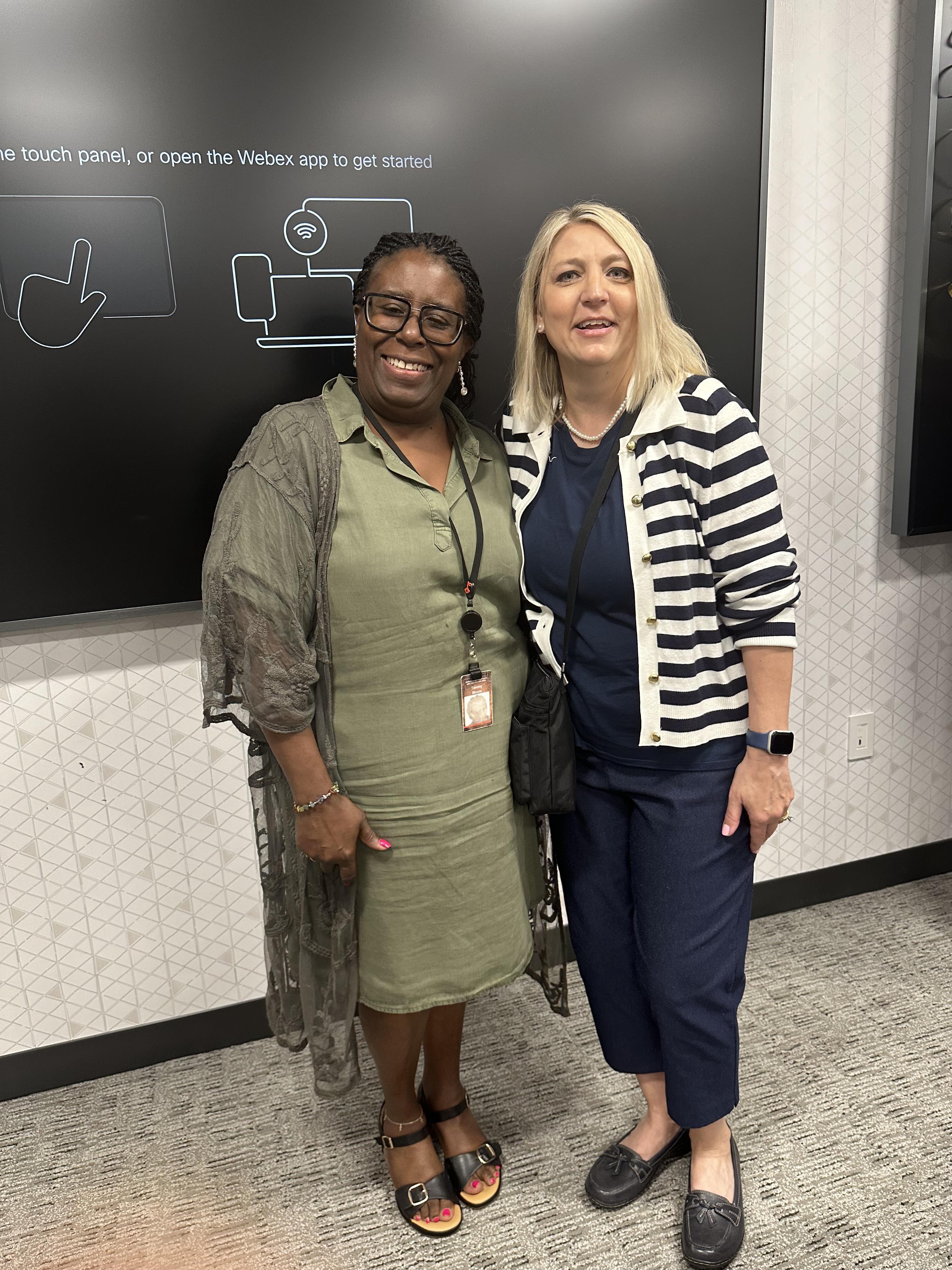 Two women standing in front of a chalkboard