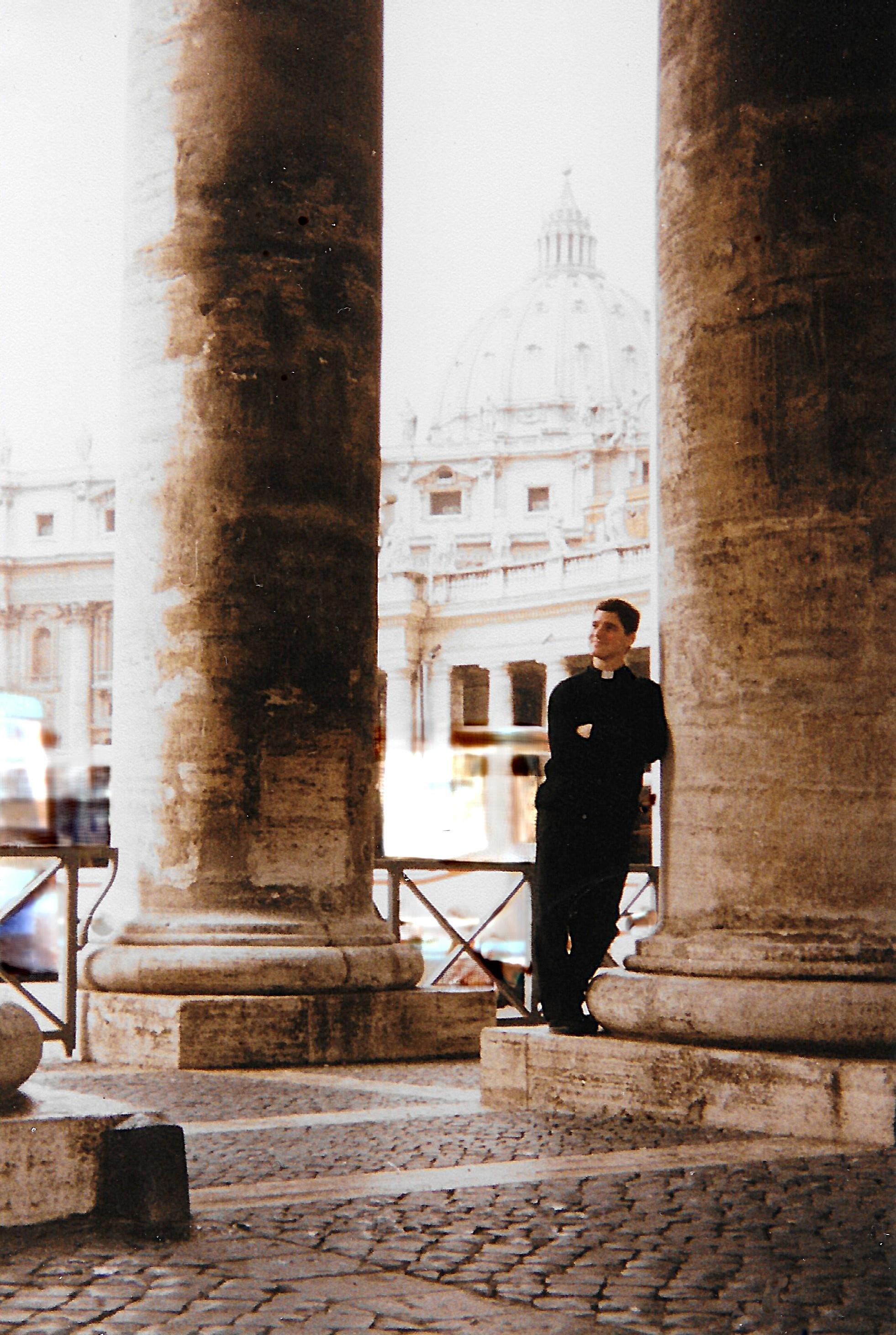 A man leaning against a pillar